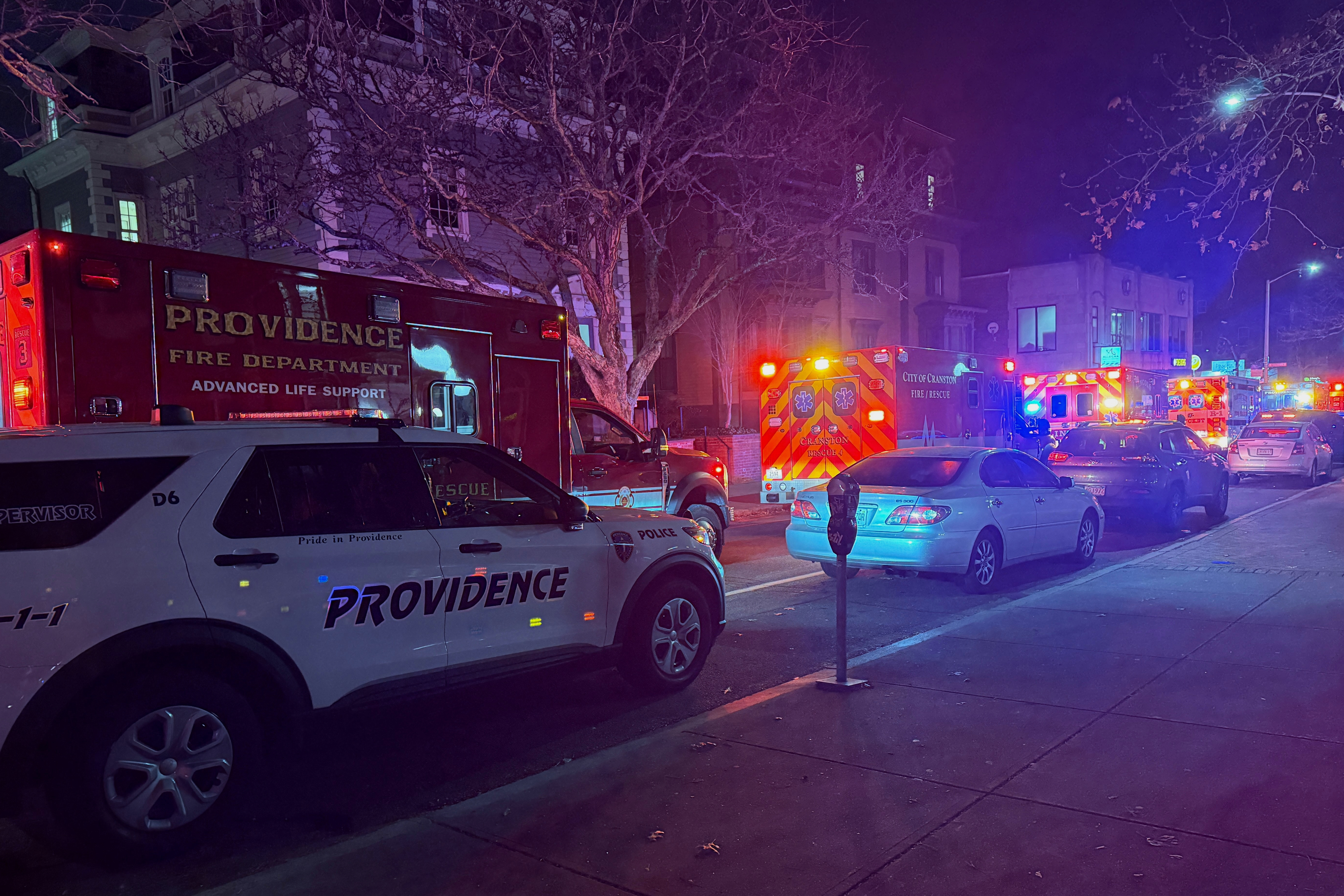 Police vehicles and first responders gather at Waterman St, and Thayer in response to a shooting, in Providence, R.I.,  Saturday, Dec. 13, 2025. (AP Photo/Jen McDermott)