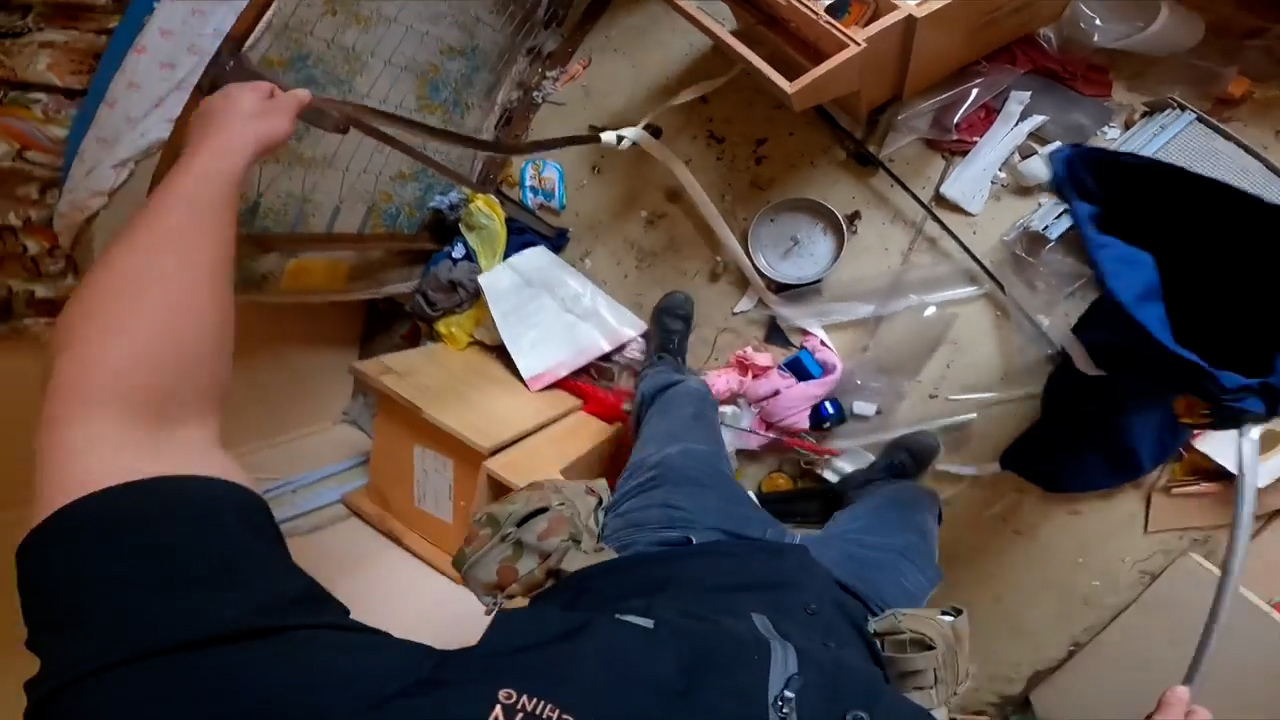 The snake was found hiding behind a tattered bed in an abandoned Queensland home.