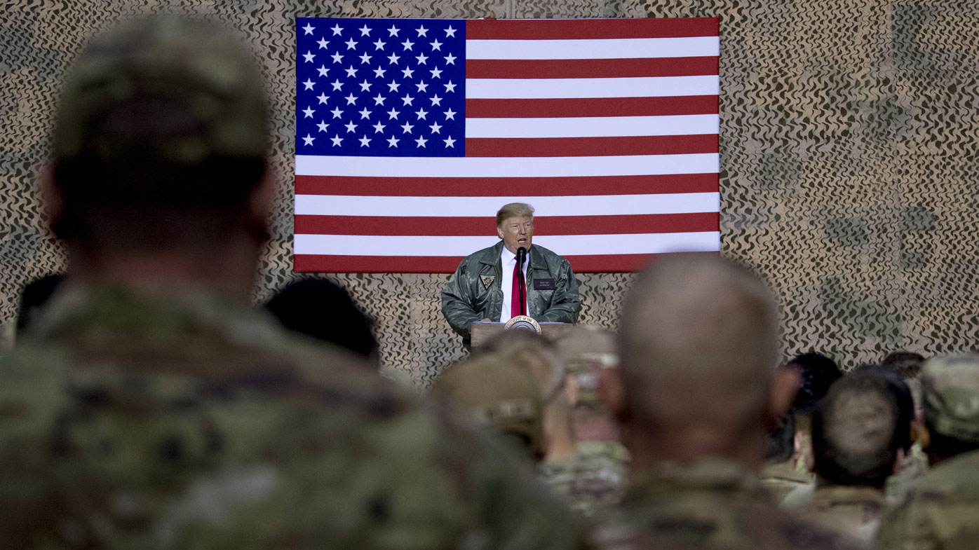 In this December 26, 2018, file photo, President Donald Trump speaks to members of the military at a hangar rally at Ain al-Asad air base, Iraq.