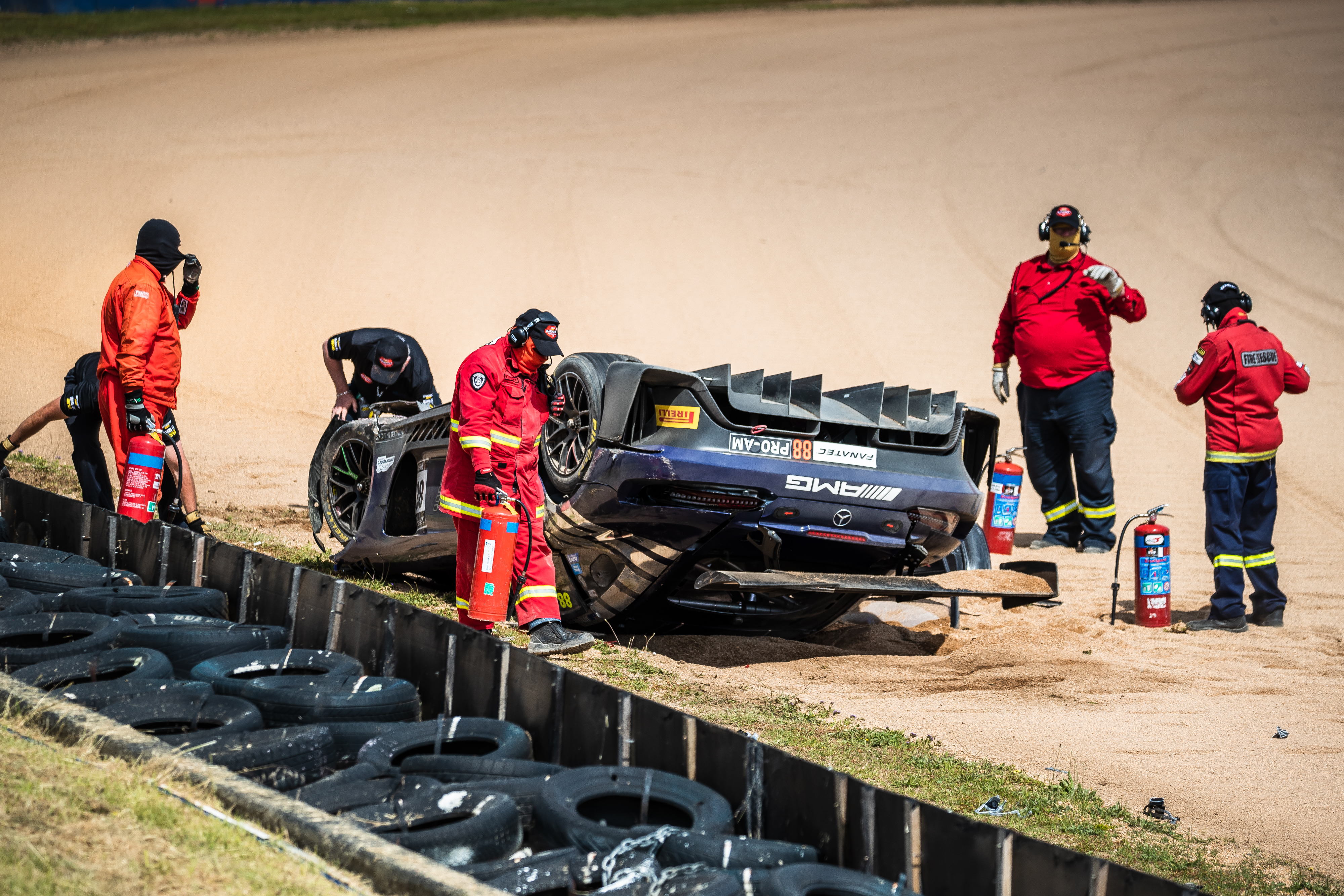 Trackside marshalls attend the scene of the crash at McPhillamy Park.