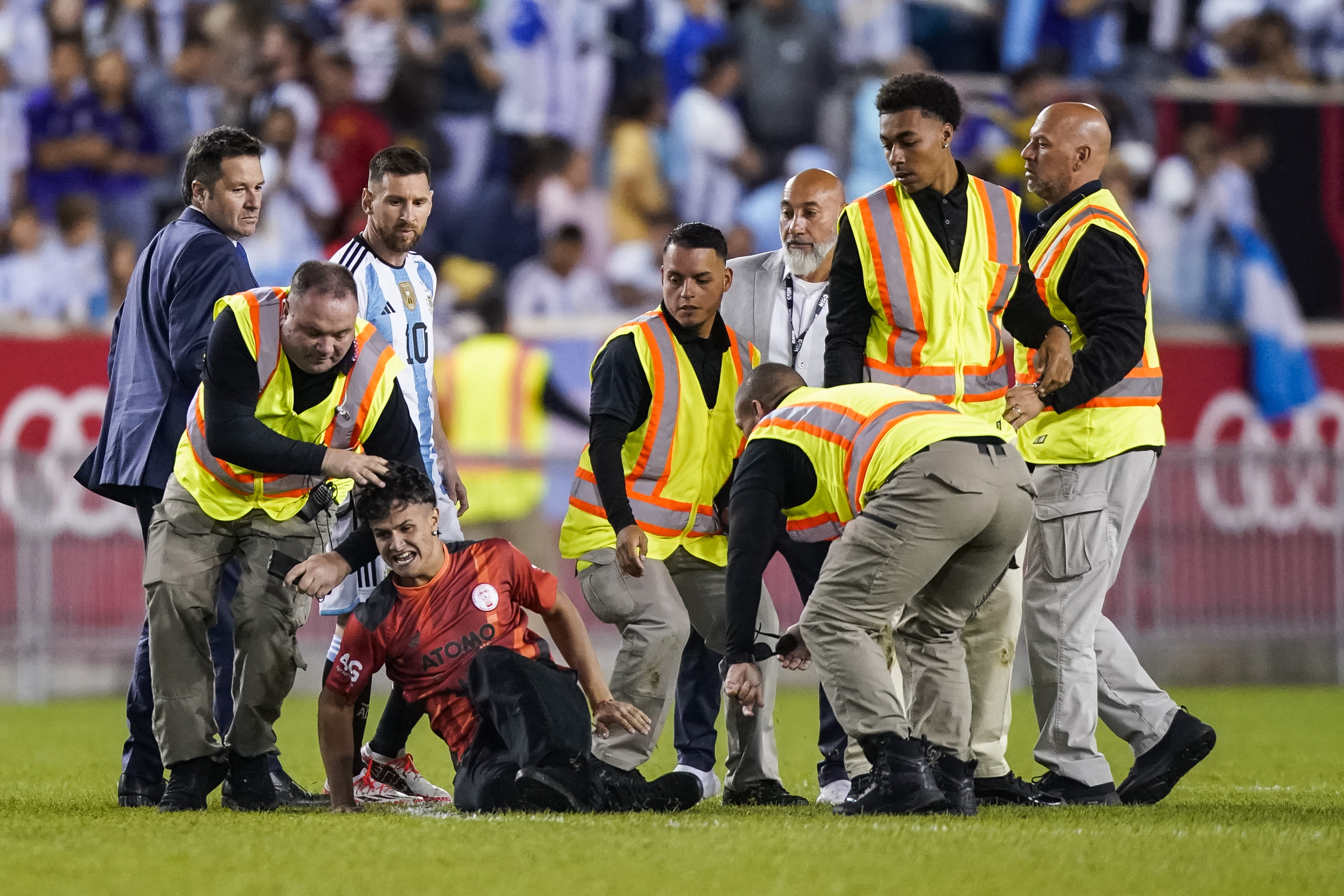 A fan is tackled as he tries to take a picture of Argentina's Lionel Messi.