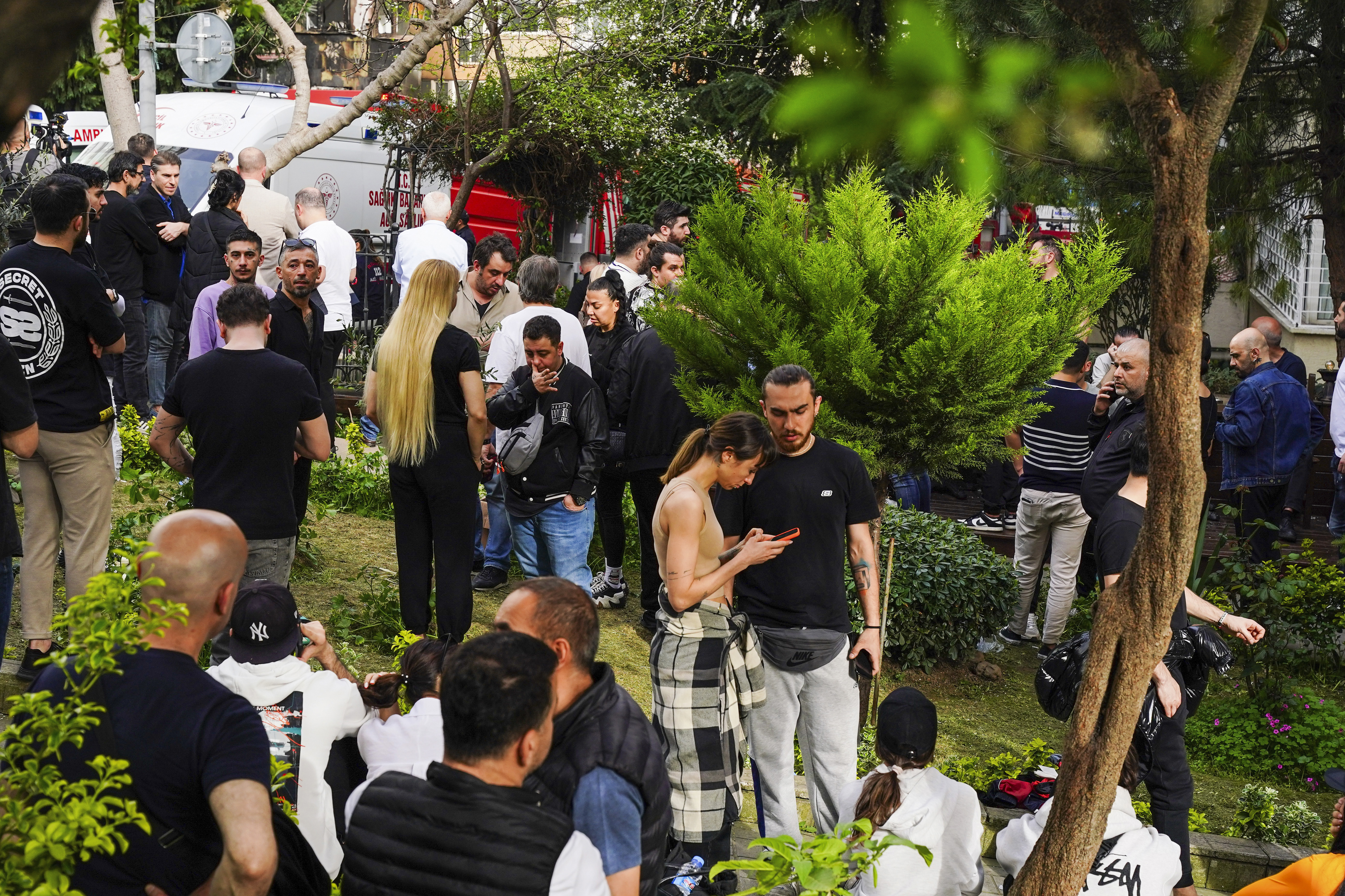 People gather as firefighters and medical teams work after a fire broke out in a nightclub, in Istanbul, Turkey, Tuesday, April 2, 2024.  