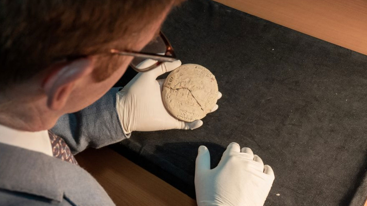 Dr Daniel Mansfield holds a clay tablet that has turned the history of mathematics on its head.