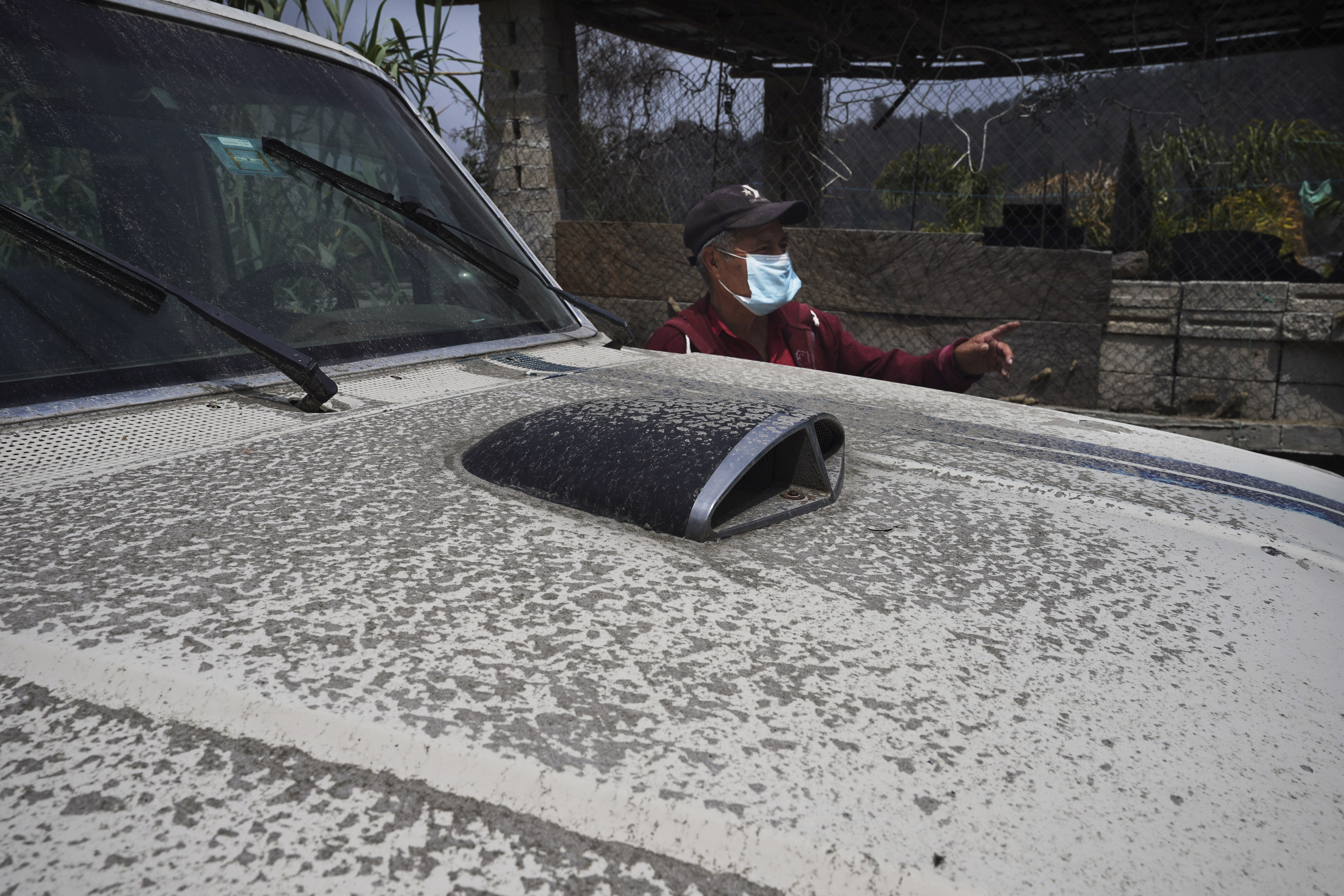 Esteban De Olarte Agustin stands next to his vehicle fouled with ash from the Popocatepetl volcano that is blanketing the streets in Santiago Xalitzintla, Mexico, Monday, May 22, 2023. 