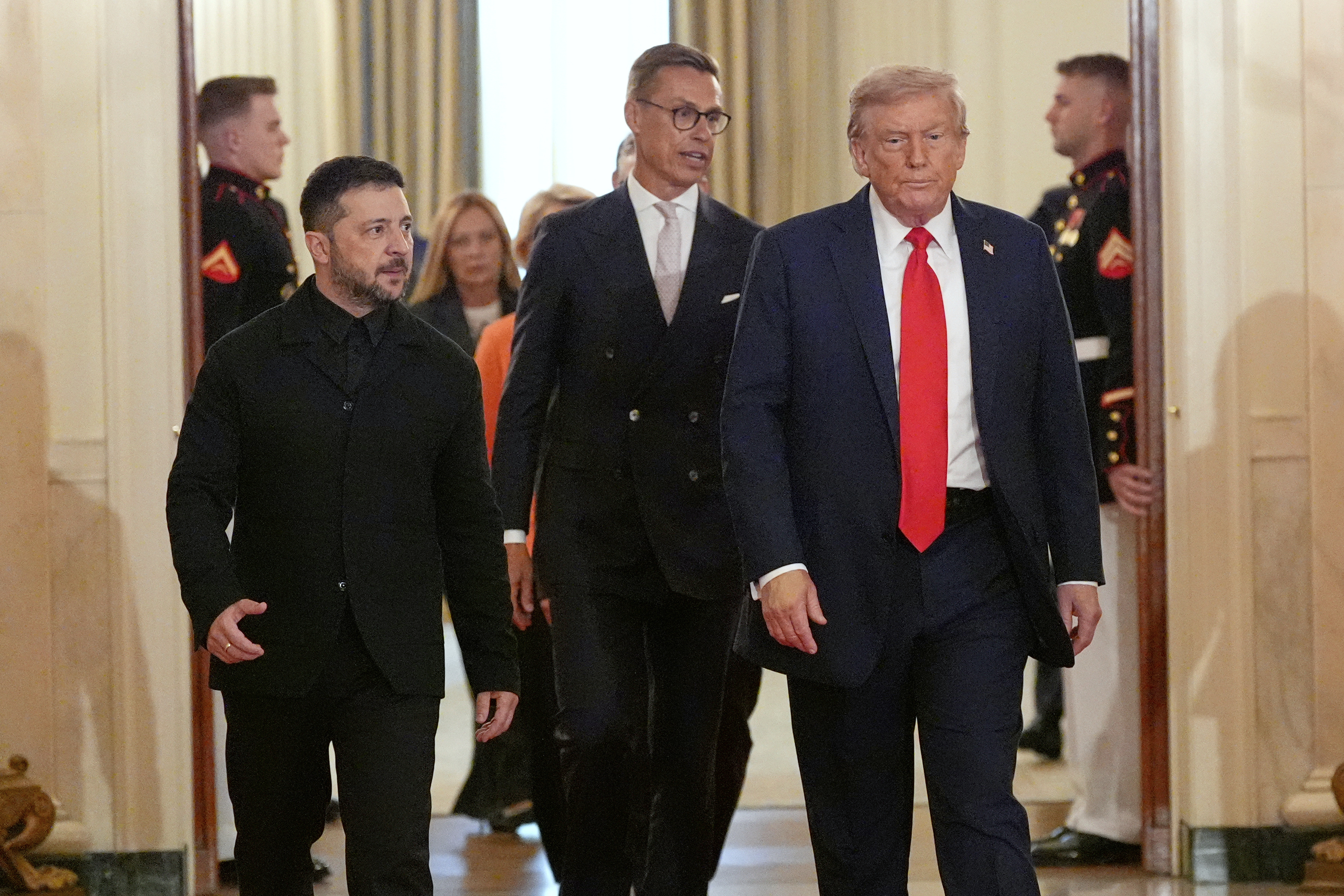 Ukraine's President Volodymyr Zelenskyy, from left, Finland's President Alexander Stubb and President Donald Trump walk through the Cross Hall of the White House, Monday, Aug. 18, 2025, in Washington.