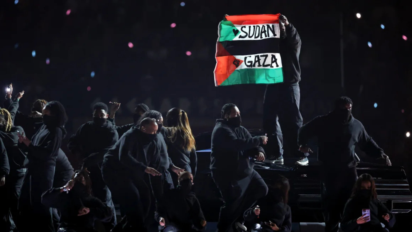 Un manifestante sostiene las banderas sudanesas y palestinas durante el show de medio tiempo del Super Bowl LIX en Caesars Superdome el domingo por la noche en Nueva Orleans.