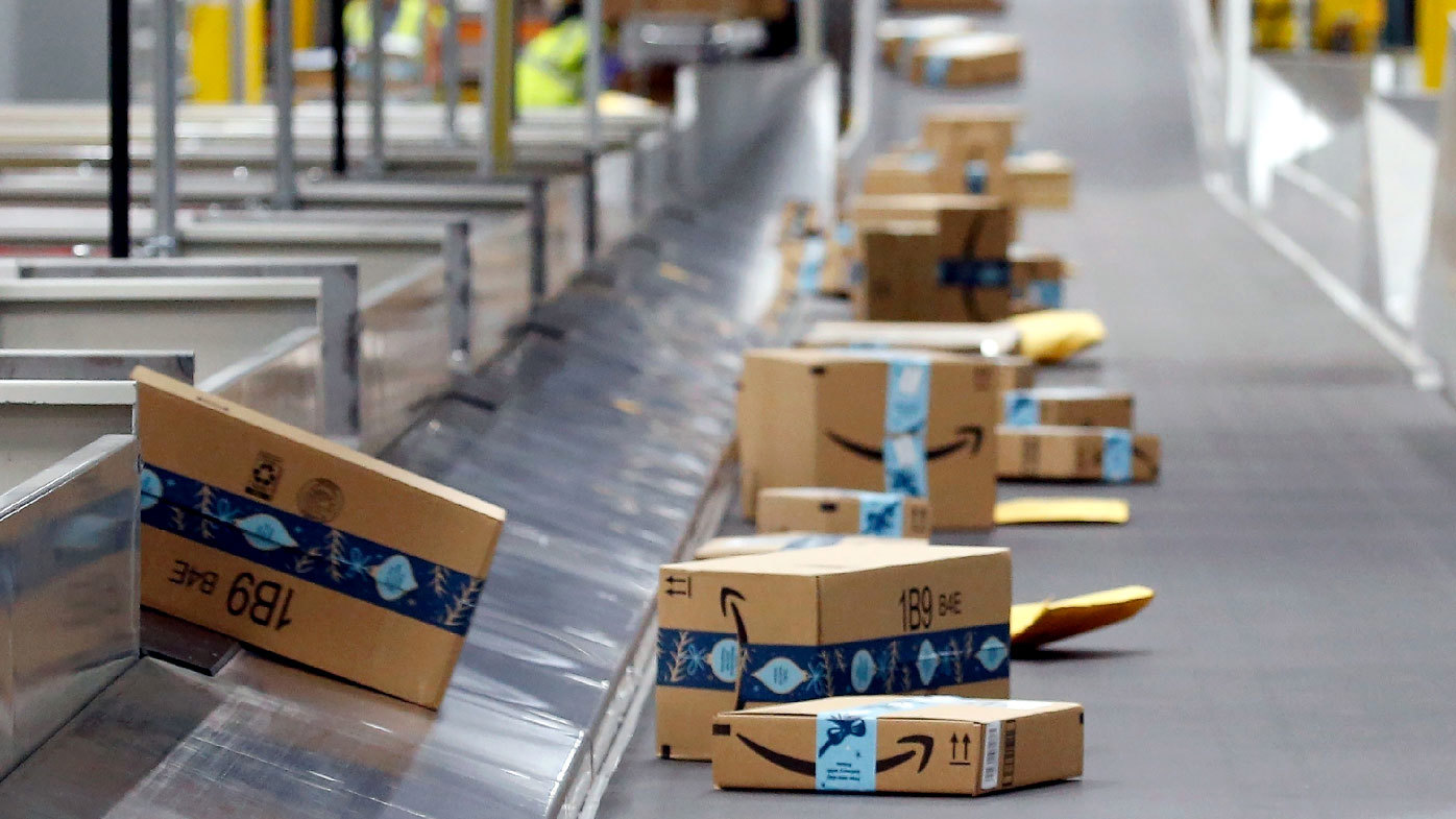 Packages move along a conveyor at an Amazon warehouse facility