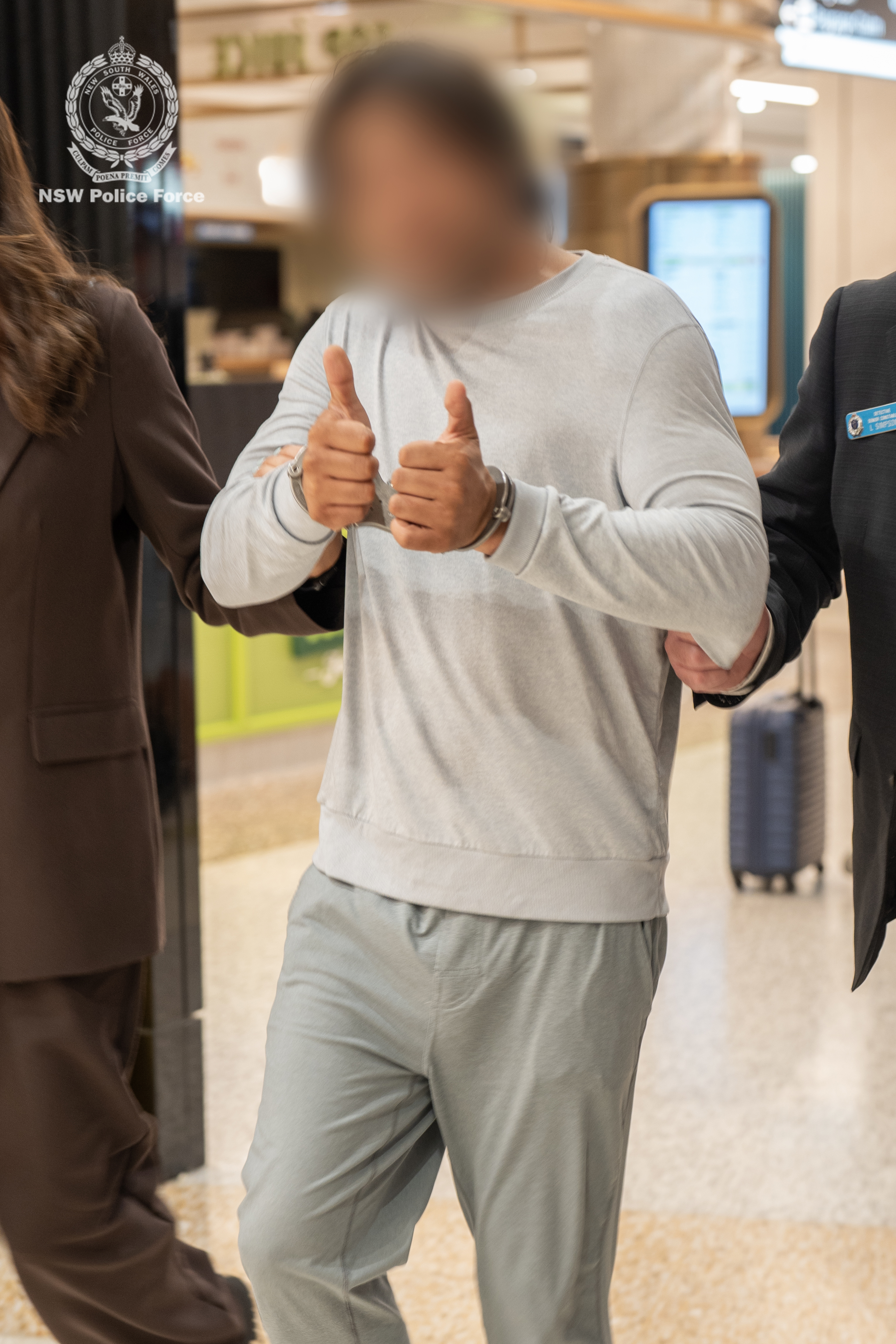 The man offered a thumbs-up sign to a camera at Sydney Airport.
