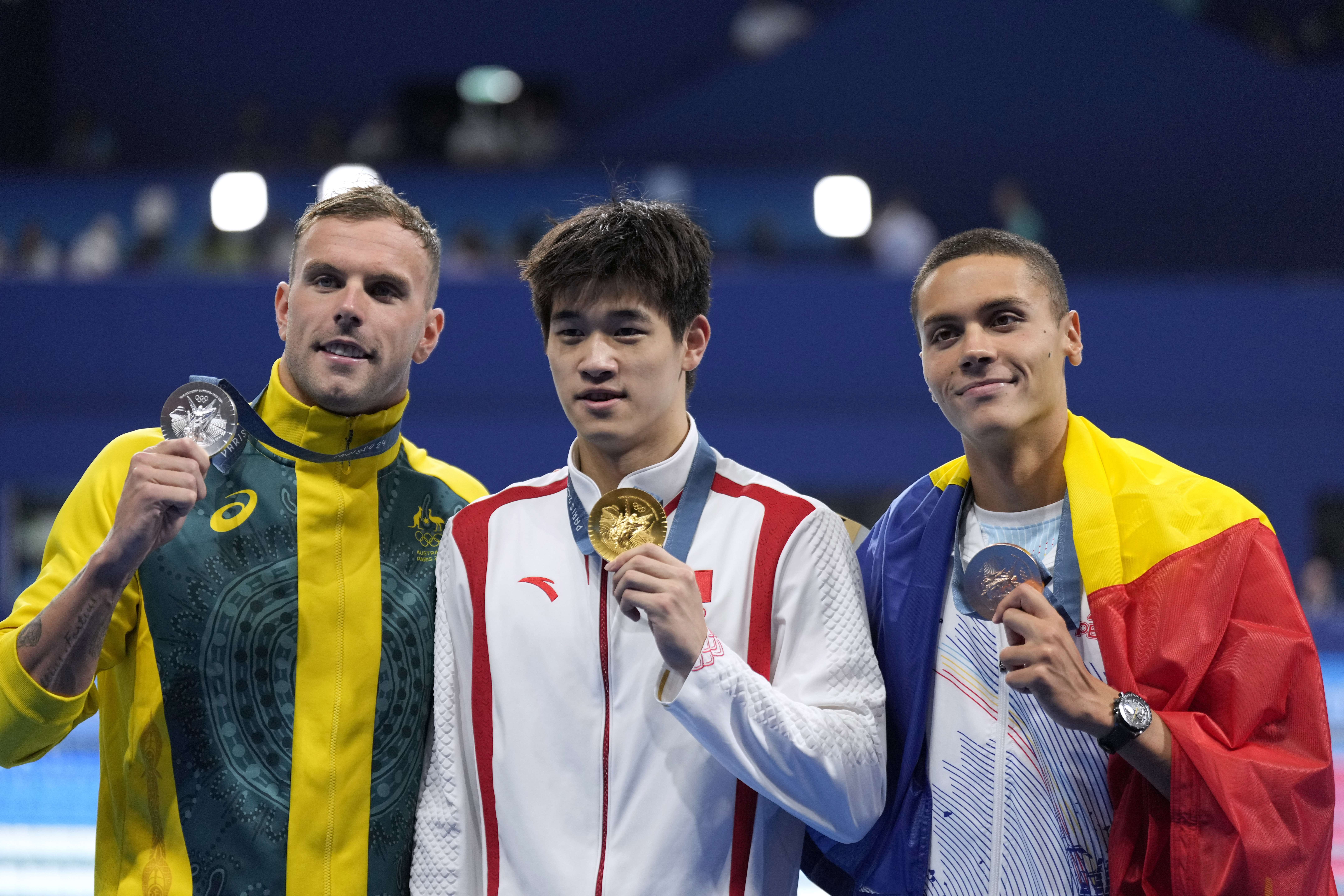 Gold medalist Pan Zhanle, of China, poses with silver medalist Kyle Chalmers, of Australia, left, and bronze medalist David Popovici, of Romania, right, after the men's 100-meter freestyle final at the 2024 Summer Olympics, Wednesday, July 31, 2024, in Nanterre, France. (AP Photo/Ashley Landis)