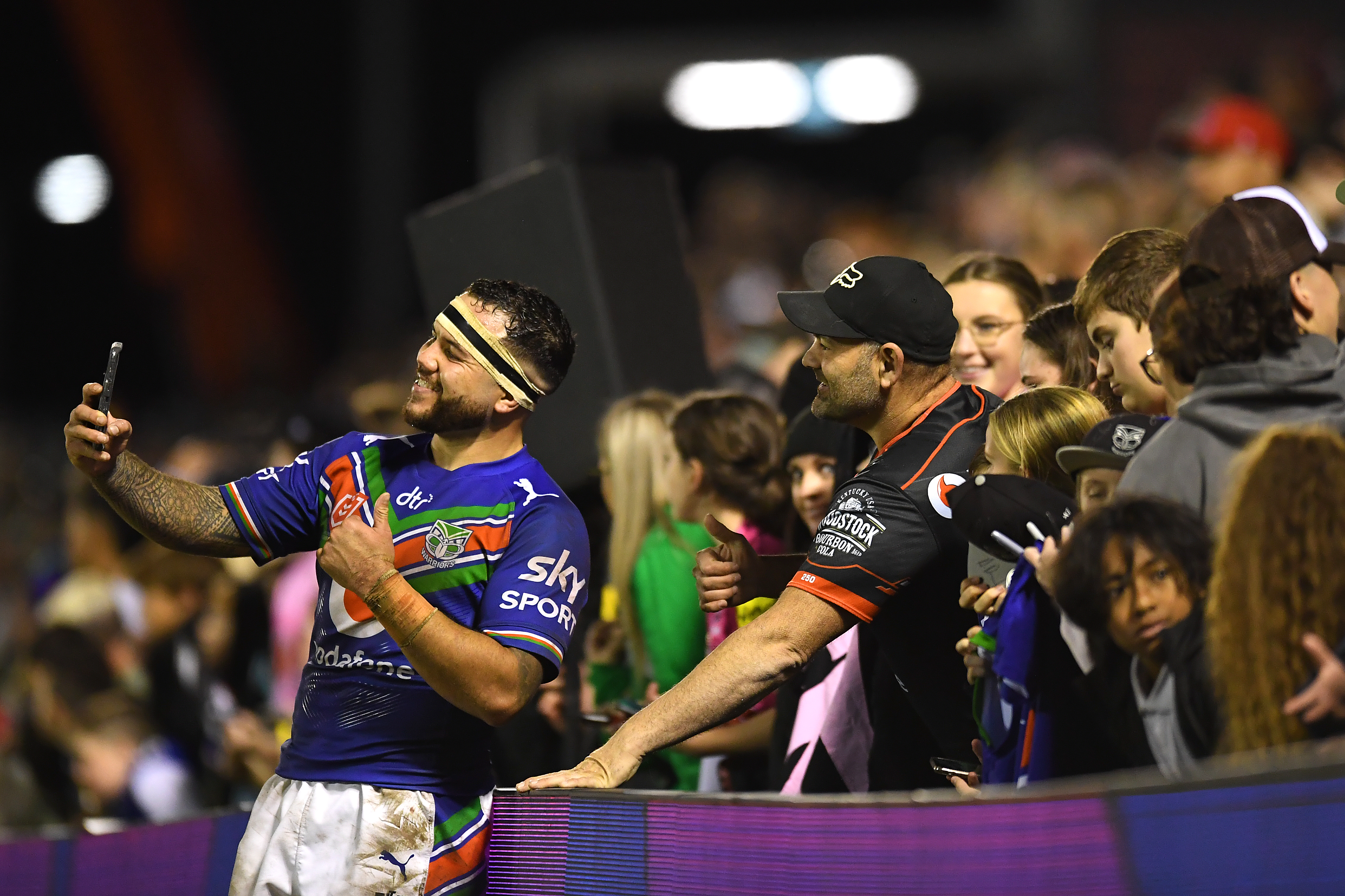 Jazz Tevaga of the Warriors takes selfies with fans after the round 15 NRL match between the New Zealand Warriors and the Penrith Panthers at Moreton Daily Stadium, on June 18, 2022, in Brisbane, Australia. (Photo by Albert Perez/Getty Images)
