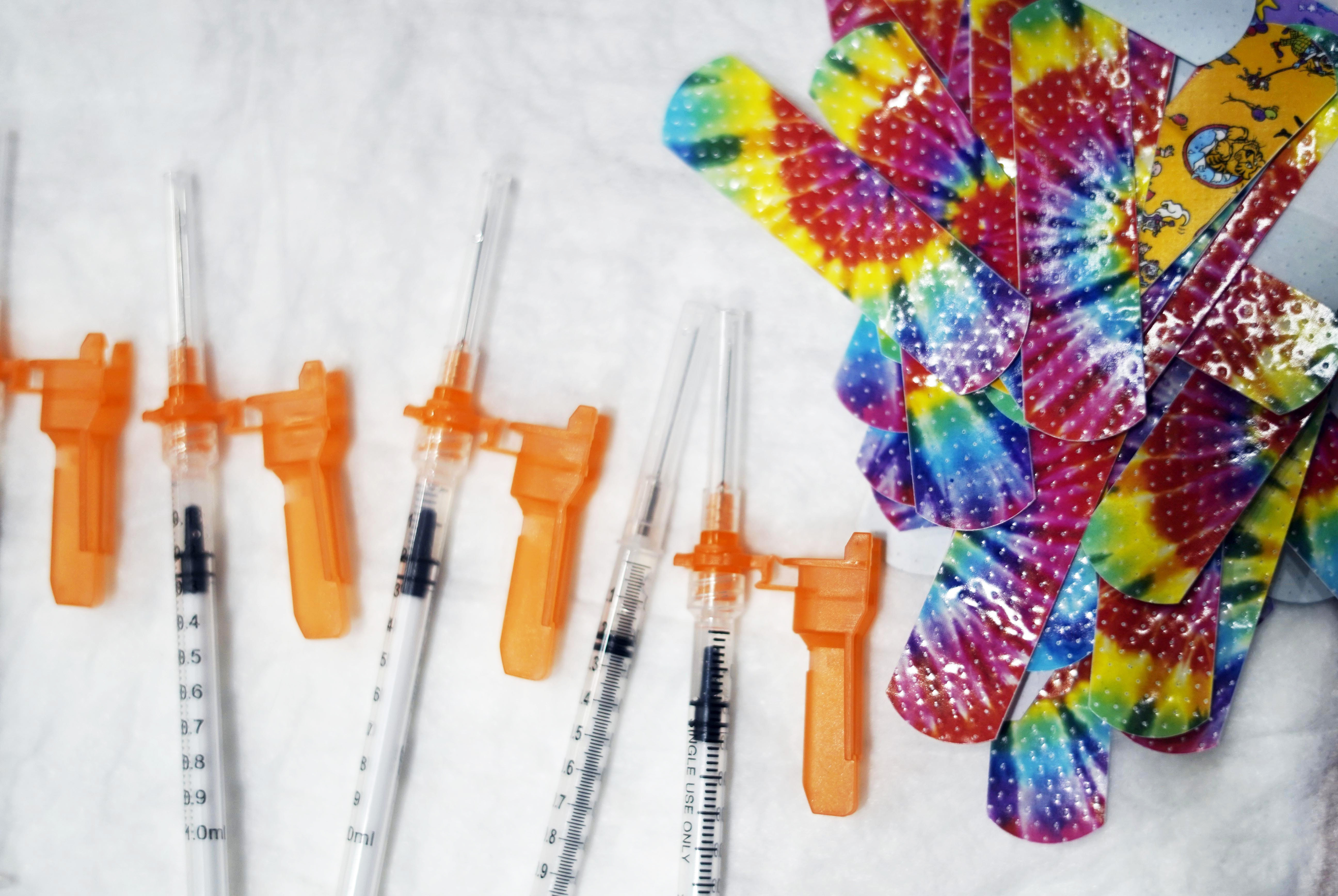 Syringes and colorful bandages are prepared as children from local schools prepare to get COVID-19 vaccines in Pittsfield, Mass., on Monday Dec. 13, 2021.