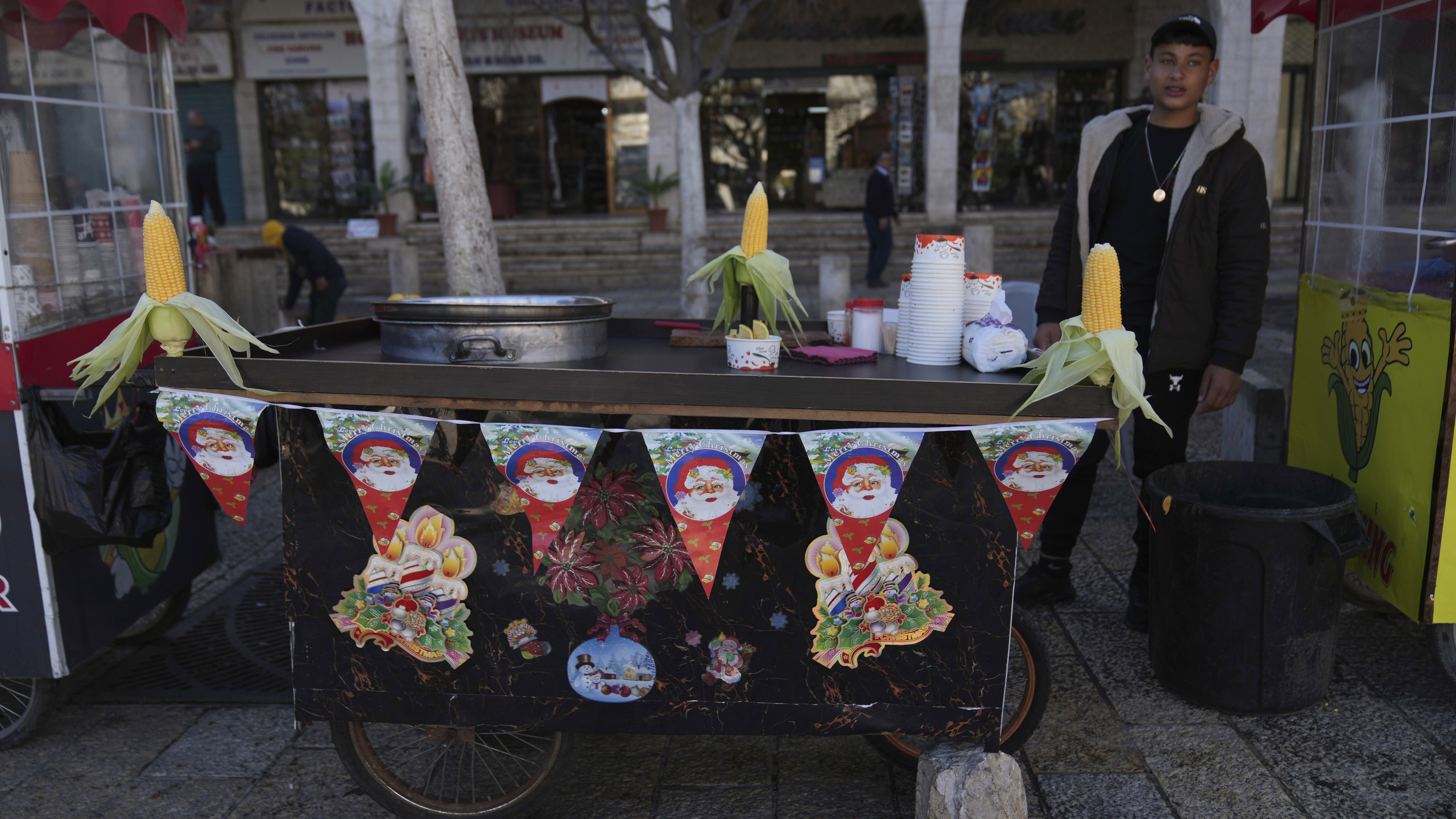 A street vendor displays corn cobs on his cart at Manger Square, adjacent to the Church of the Nativity, traditionally recognized by Christians to be the birthplace of Jesus Christ, on Christmas Day in the West Bank city of Bethlehem Tuesday, Dec. 24, 2024. (AP Photo/Nasser Nasser)