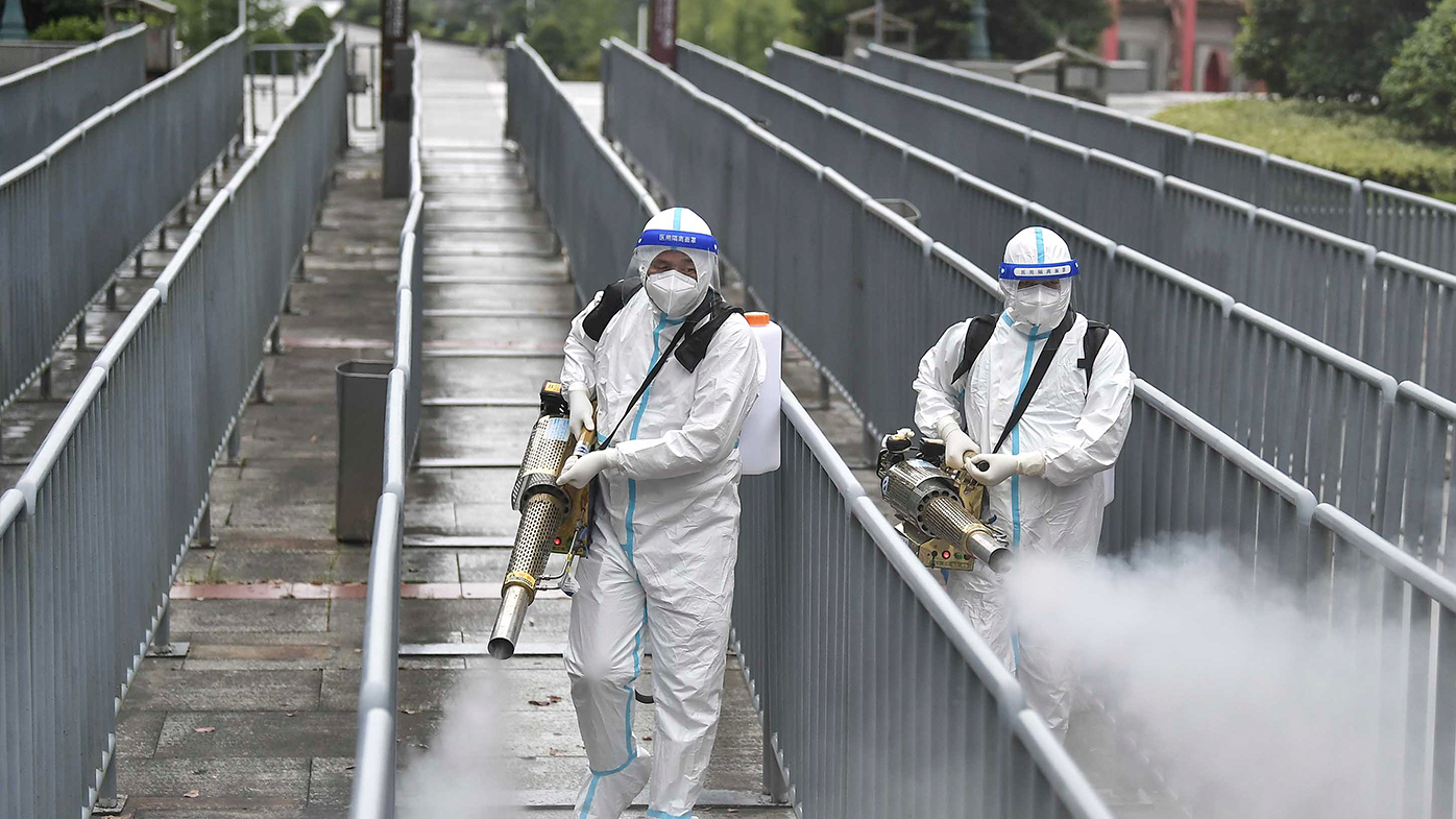 Workers spray disinfectant to halt the spread of COVID-19 on August 26, in Zhangjiajie, Hunan Province of China.