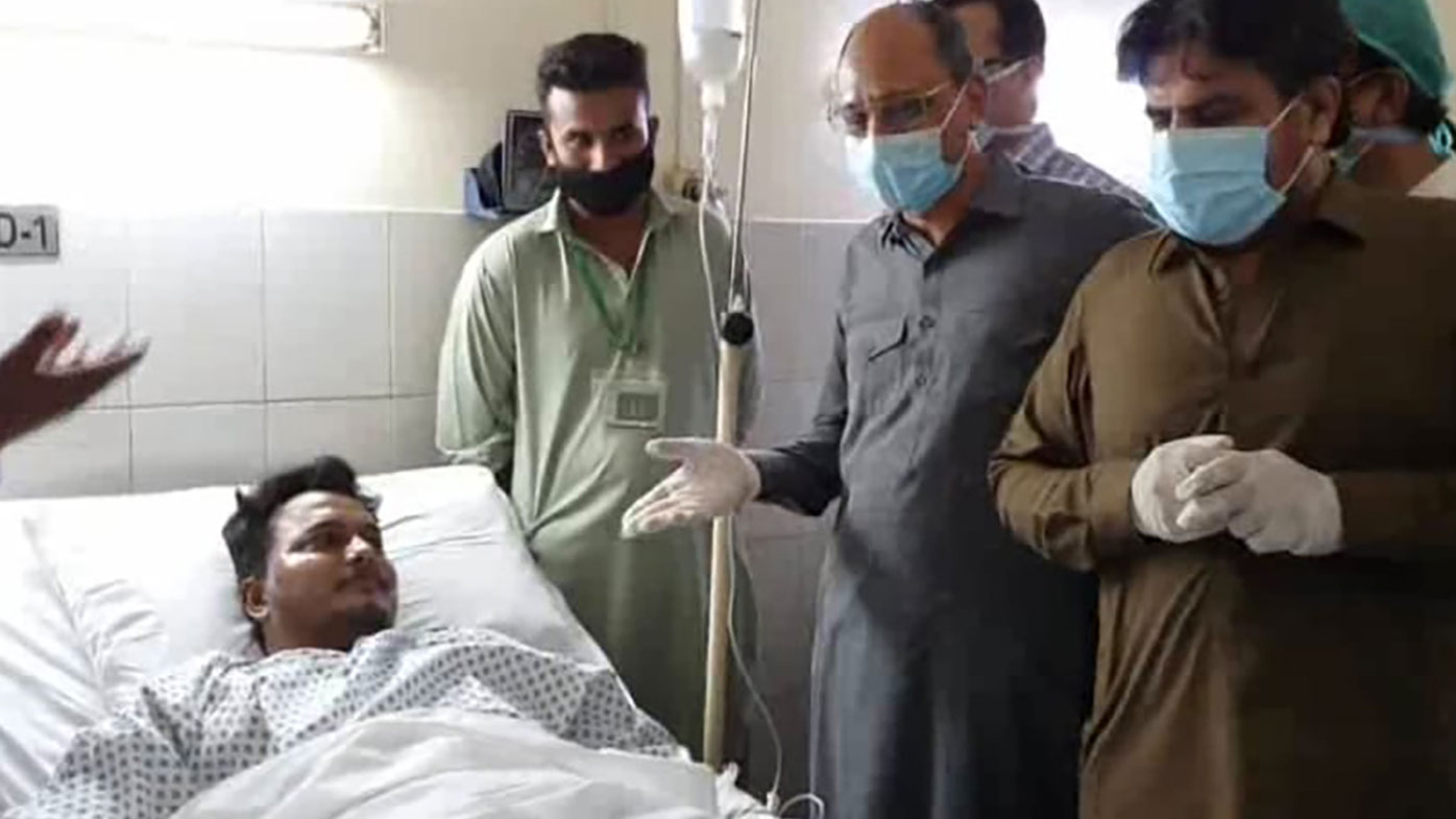 In this photo released by the Sindh Press Information Department, Pakistani provincial minister Saeed Ghani, second from right, meets Mohammad Zubair who survived a plane crash, at a hospital in Karachi, Pakistan, Friday, May 22, 2020