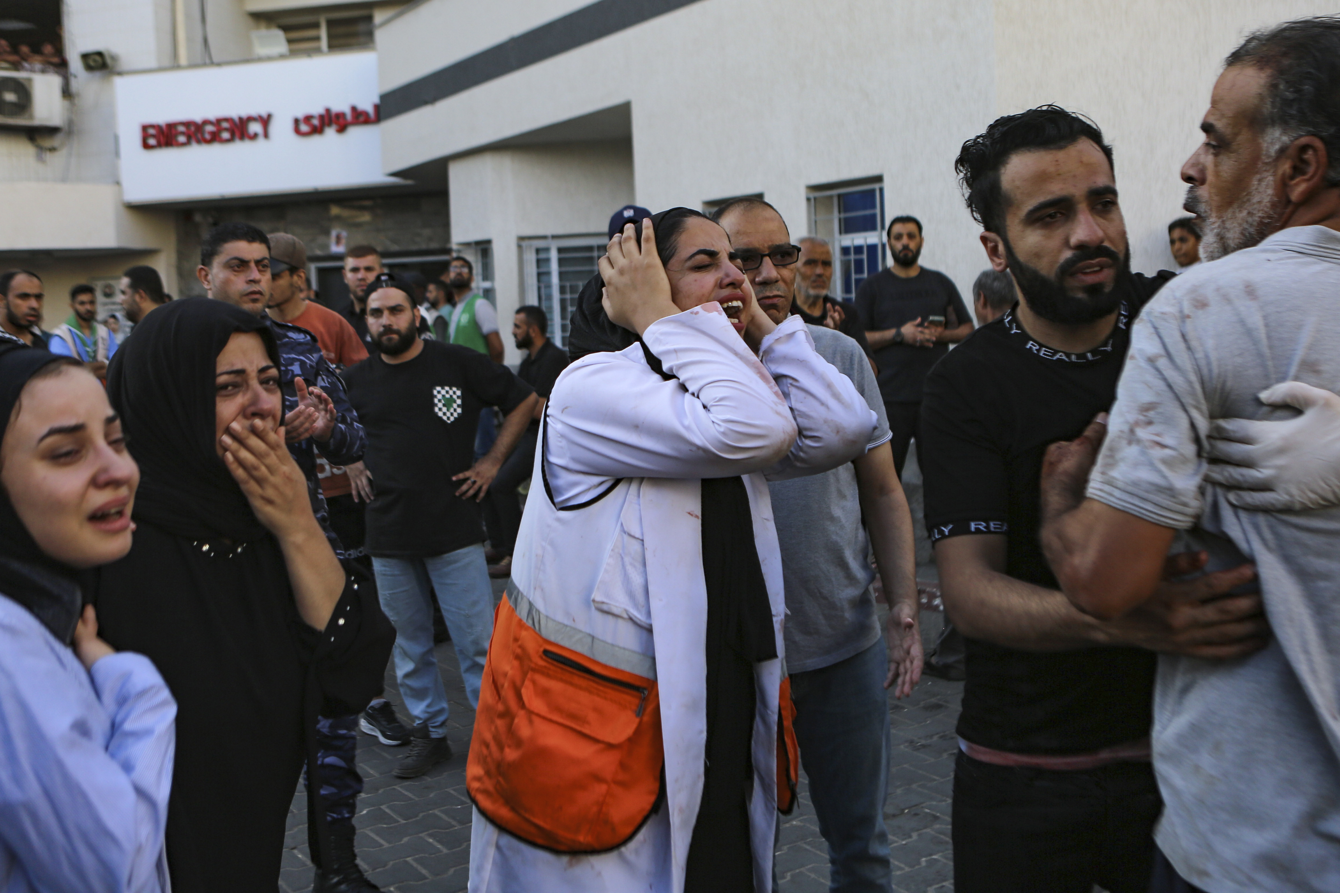 A Palestinian medic, center, and others cry after learning about the death of a relative at the al-Shifa hospital, following Israeli airstrikes on Gaza City, central Gaza Strip, Tuesday, Oct. 17, 2023. 