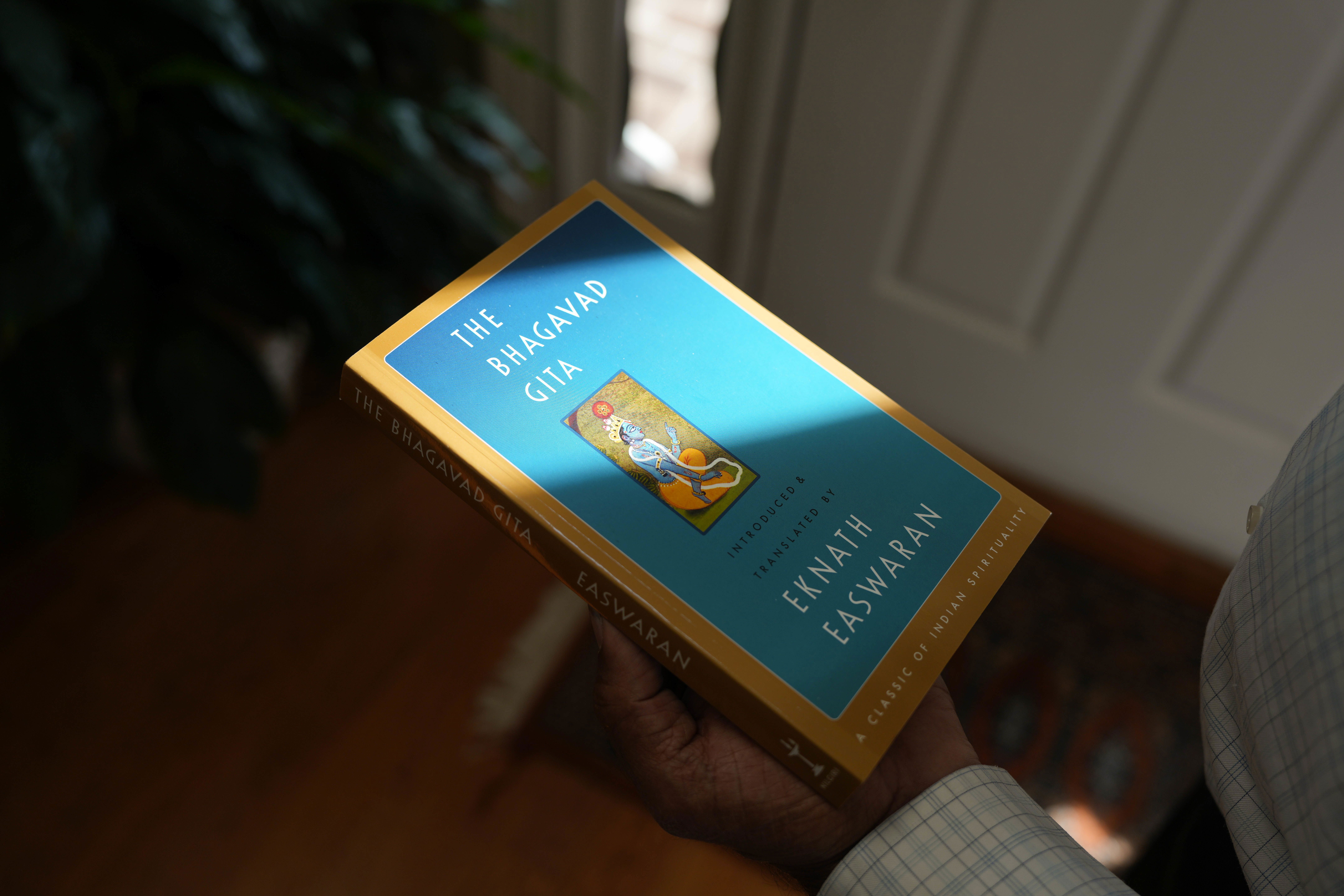 Mahendra "Mick" Patel shows a copy of the Bhagvad Gita he read while he was in jail.