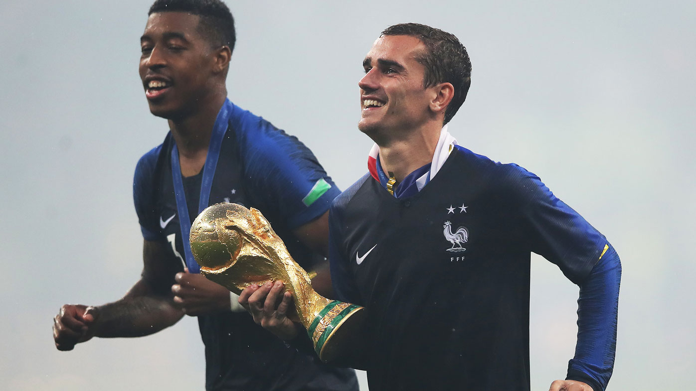 Antoine Griezmann celebrates with the World Cup.
