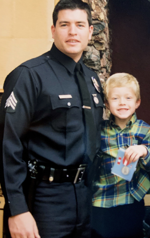 Detective Tim Shaw pictured with his son Tyler, who holds the Los Angeles Police Department medal his father was awarded for his role in the 1997 North Hollywood shootout. 
