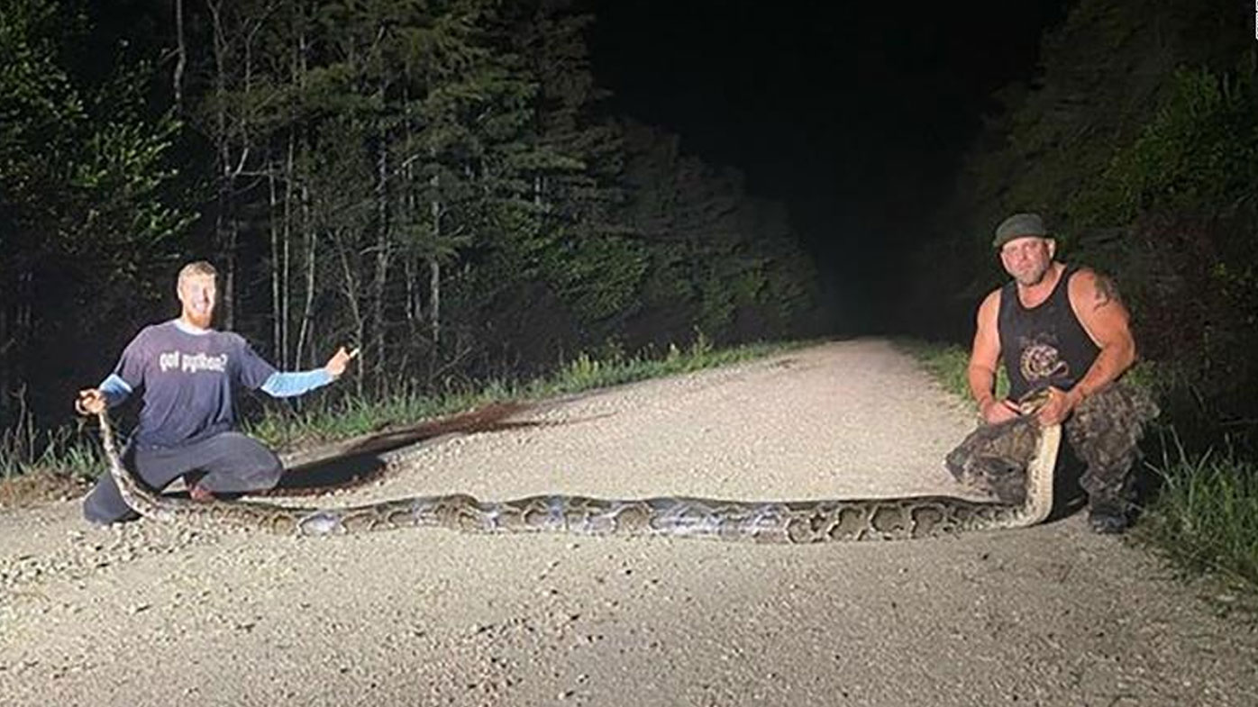 Hunters Kevin Pavlidis, left, and Ryan Ausburn hold a massive python caught as part of Florida's Python Elimination Program.