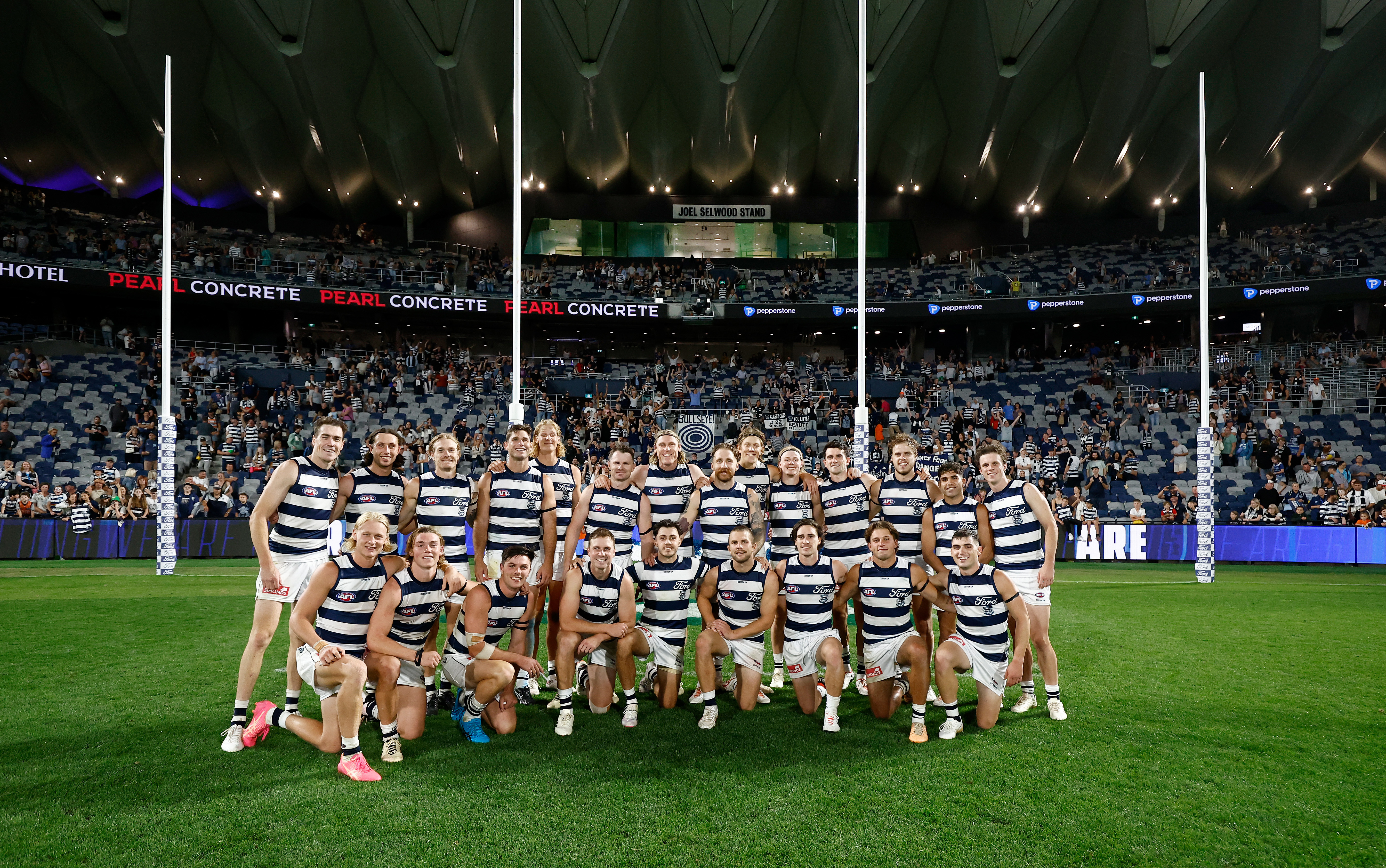 Geelong players pose in front of the new Joel Selwood Stand.