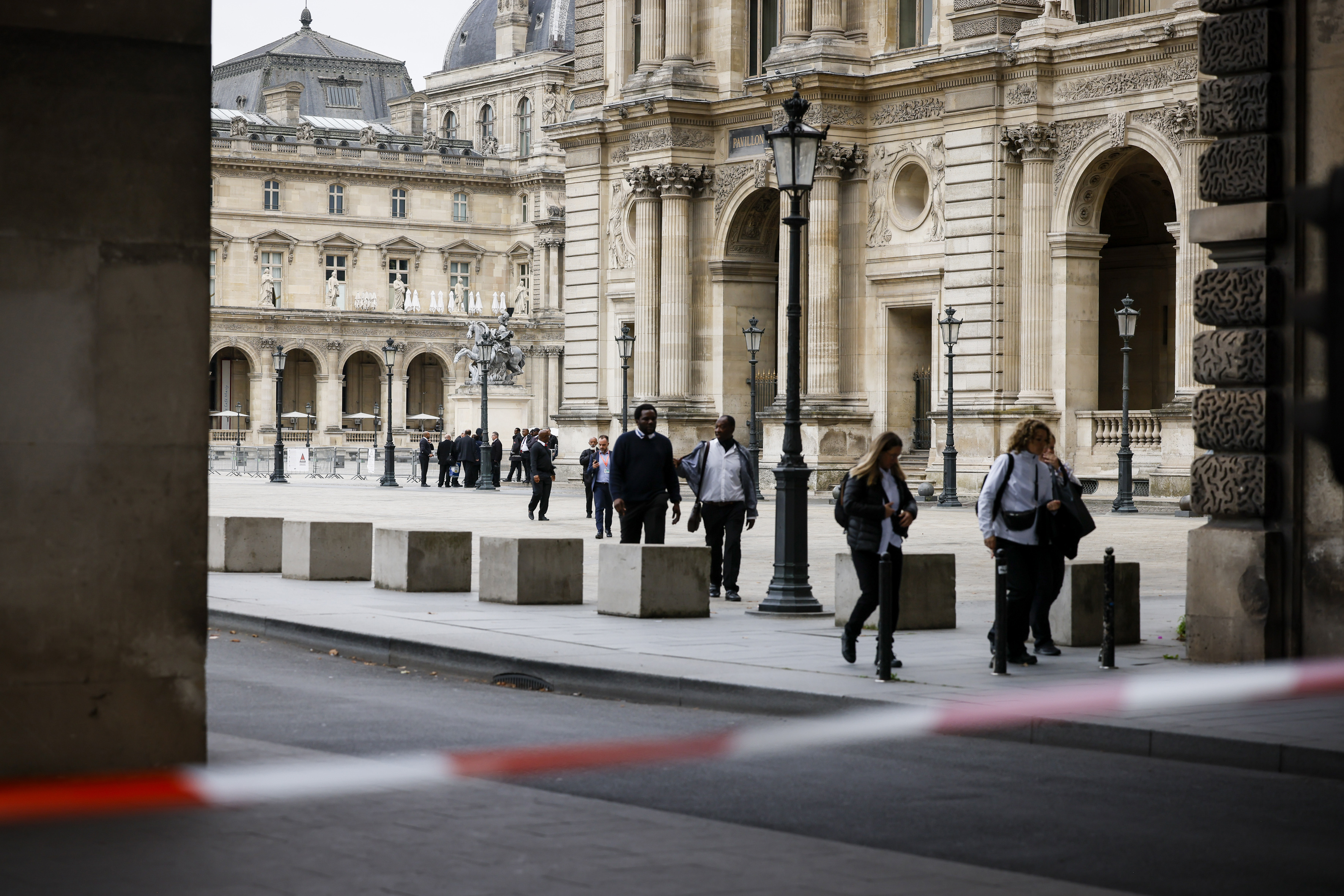 Staff leave the Louvre Museum as people are evacuated after it received a written threat, in Paris, Saturday Oct. 14, 2023. 