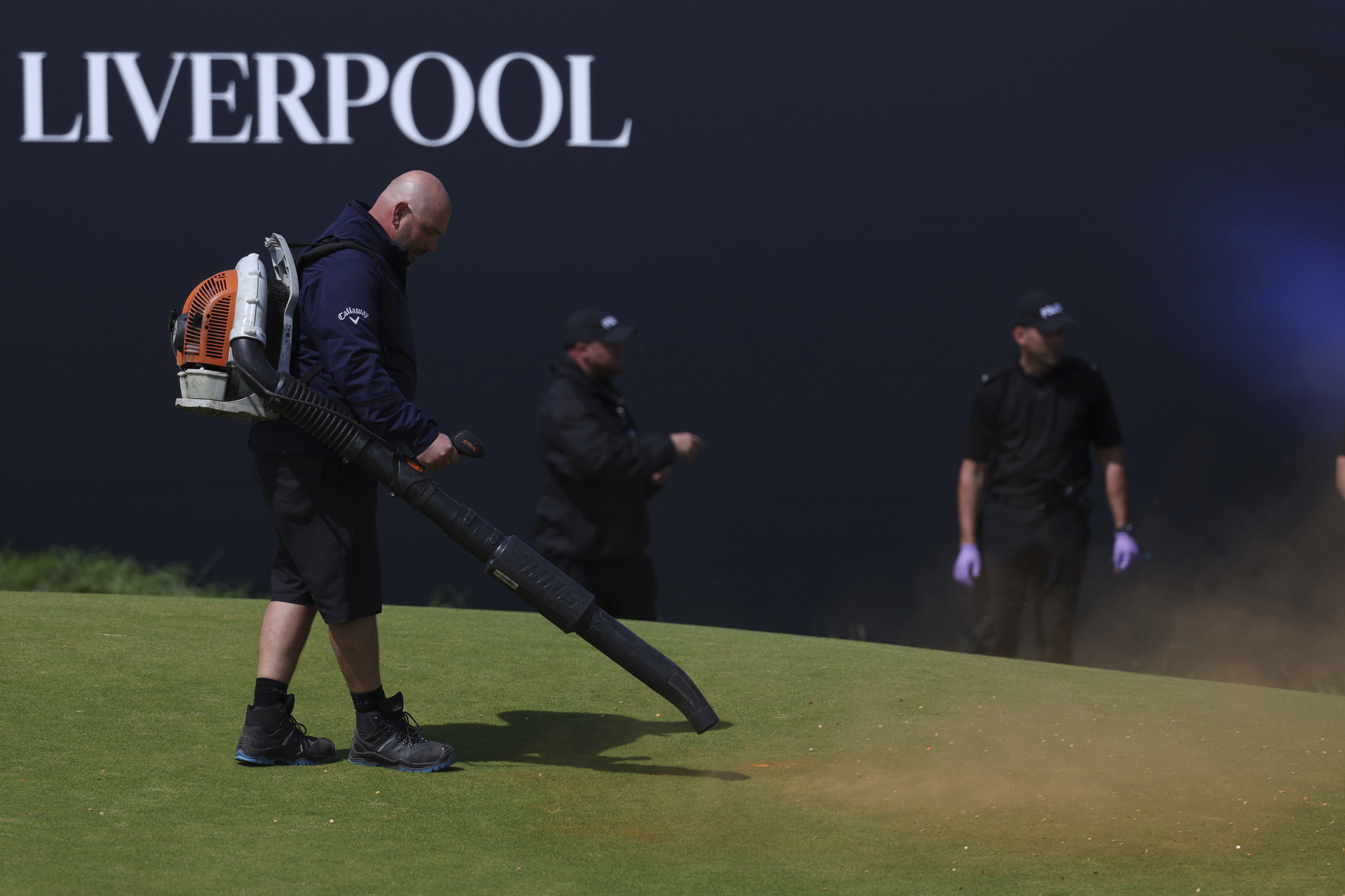 Green-keepers clear away debris after protesters threw material onto the 17th green during the second day of the British Open Golf Championships at the Royal Liverpool Golf Club in Hoylake, England, Friday, July 21, 2023. 