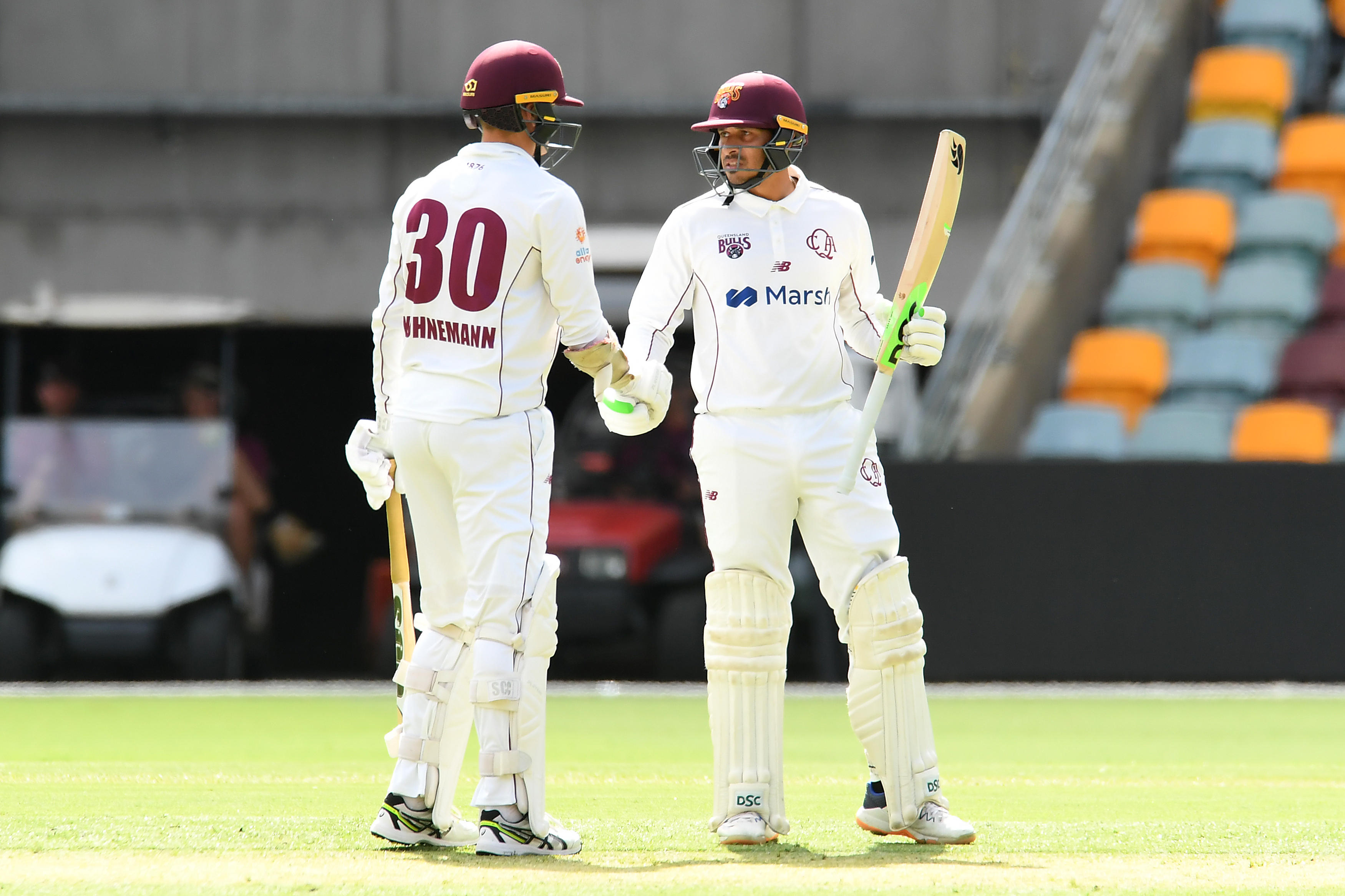 Usman Khawaja of the Bulls celebrates his half century with teammate Matthew Kuhnemann.