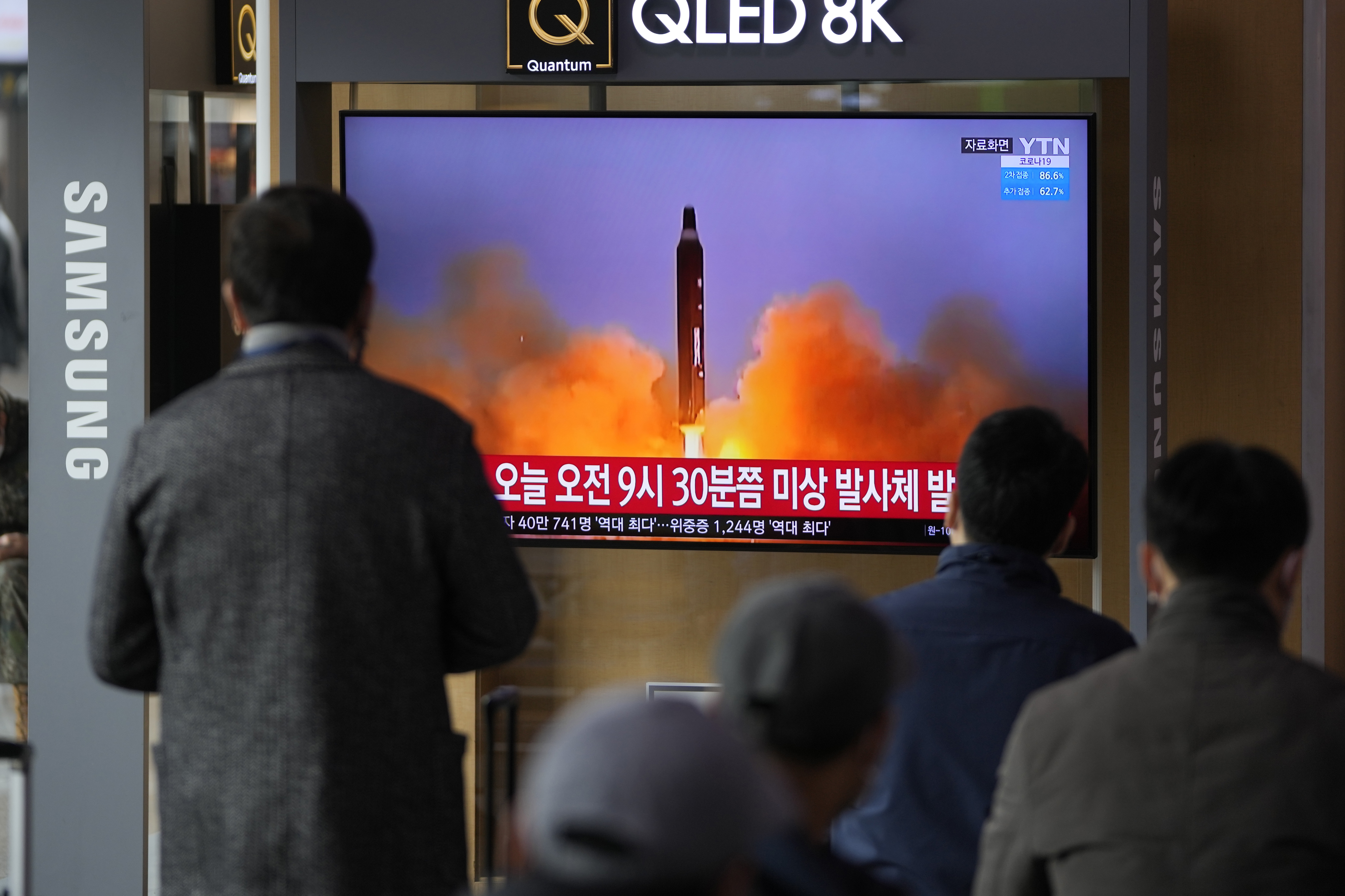 People watch a TV screen showing a news program reporting about North Korea's missile with file footage, at a train station in Seoul, South Korea. 
