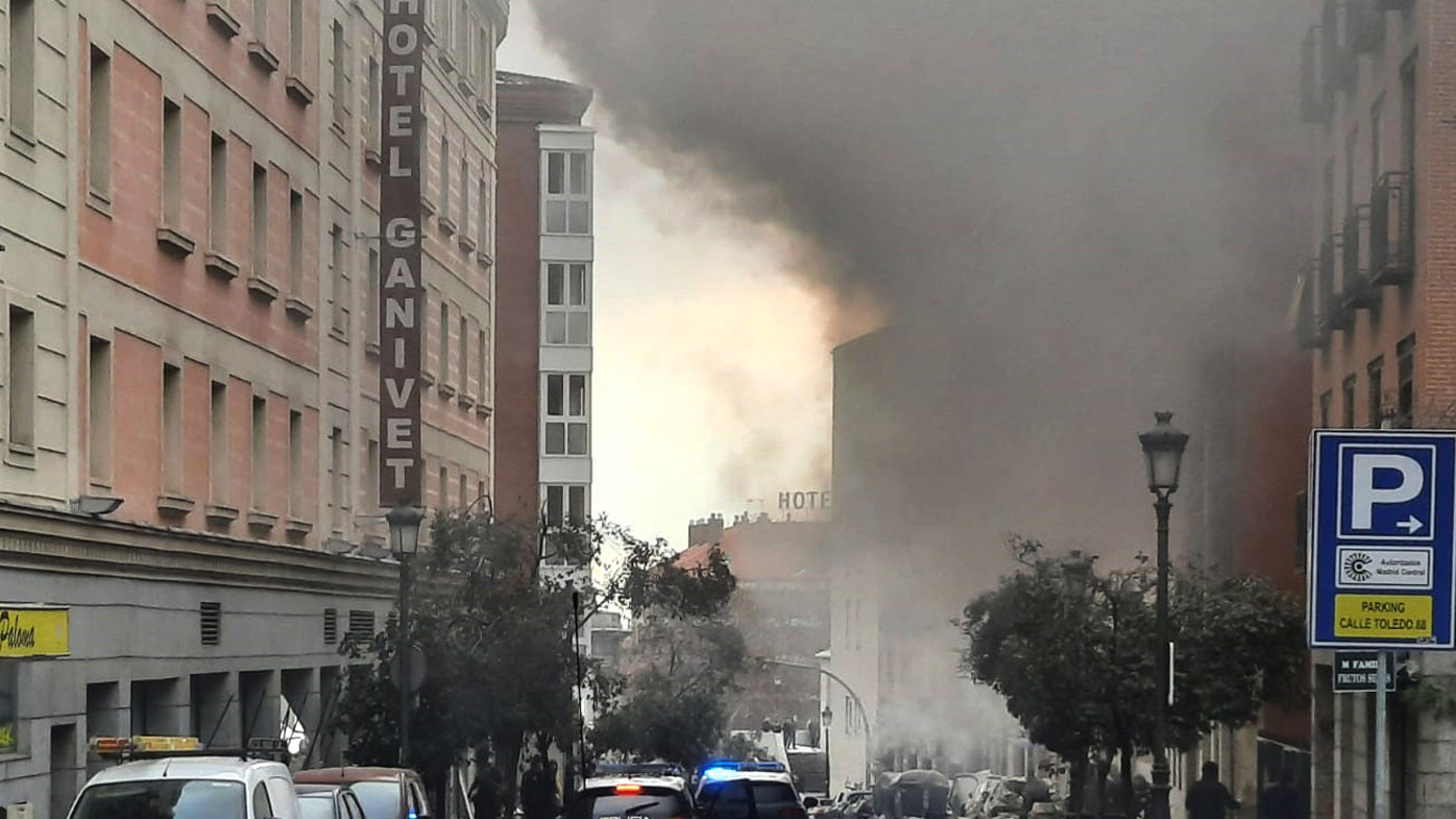 Smoke rises from a building and rubble scattered in Toledo Street following a explosion in downtown Madrid, Spain, Wednesday, Jan. 20, 2021