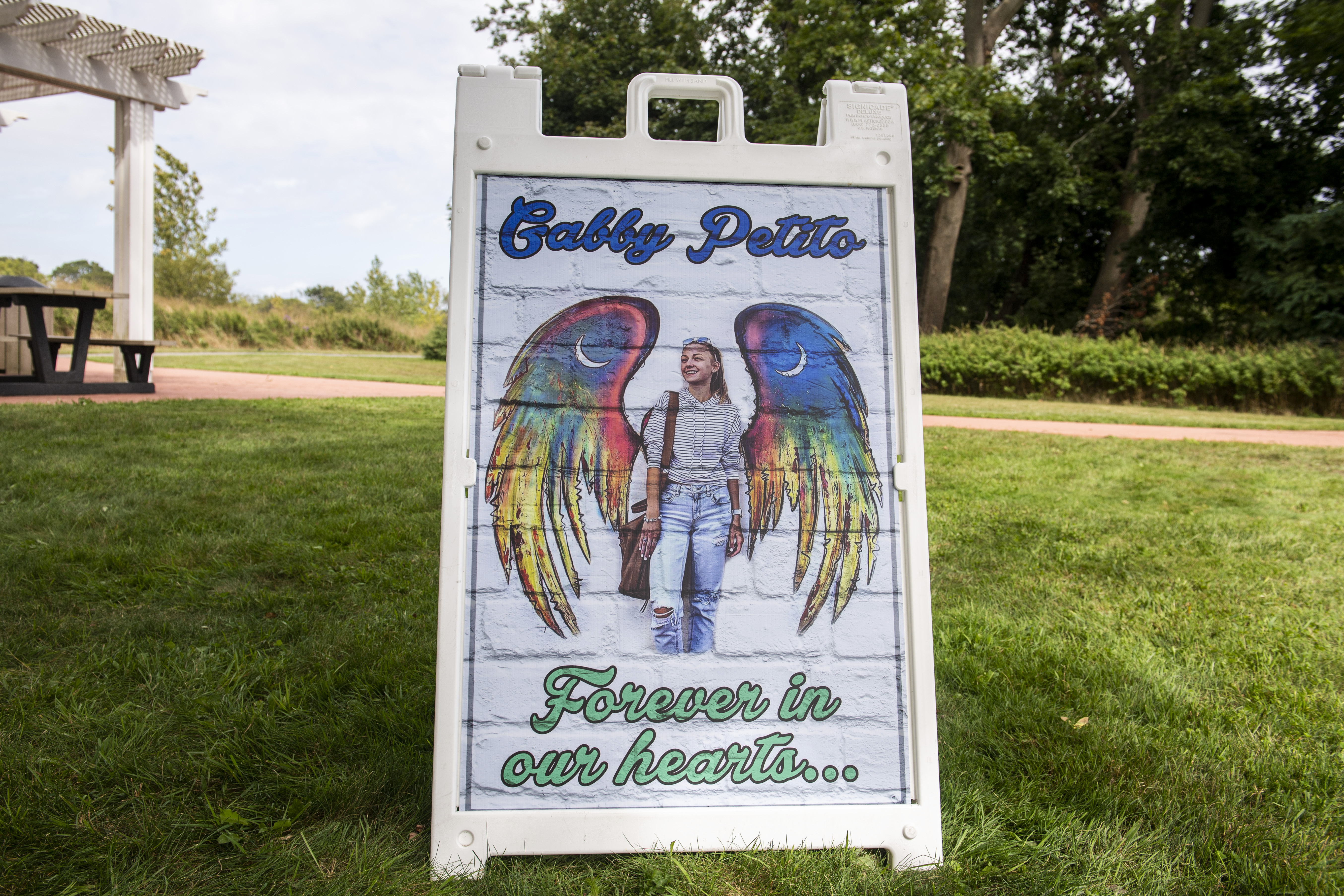 People donate money and distribute candles that will be later be lit in unison in support of the Petito family in Blue Point Nature Preserve park in New York.