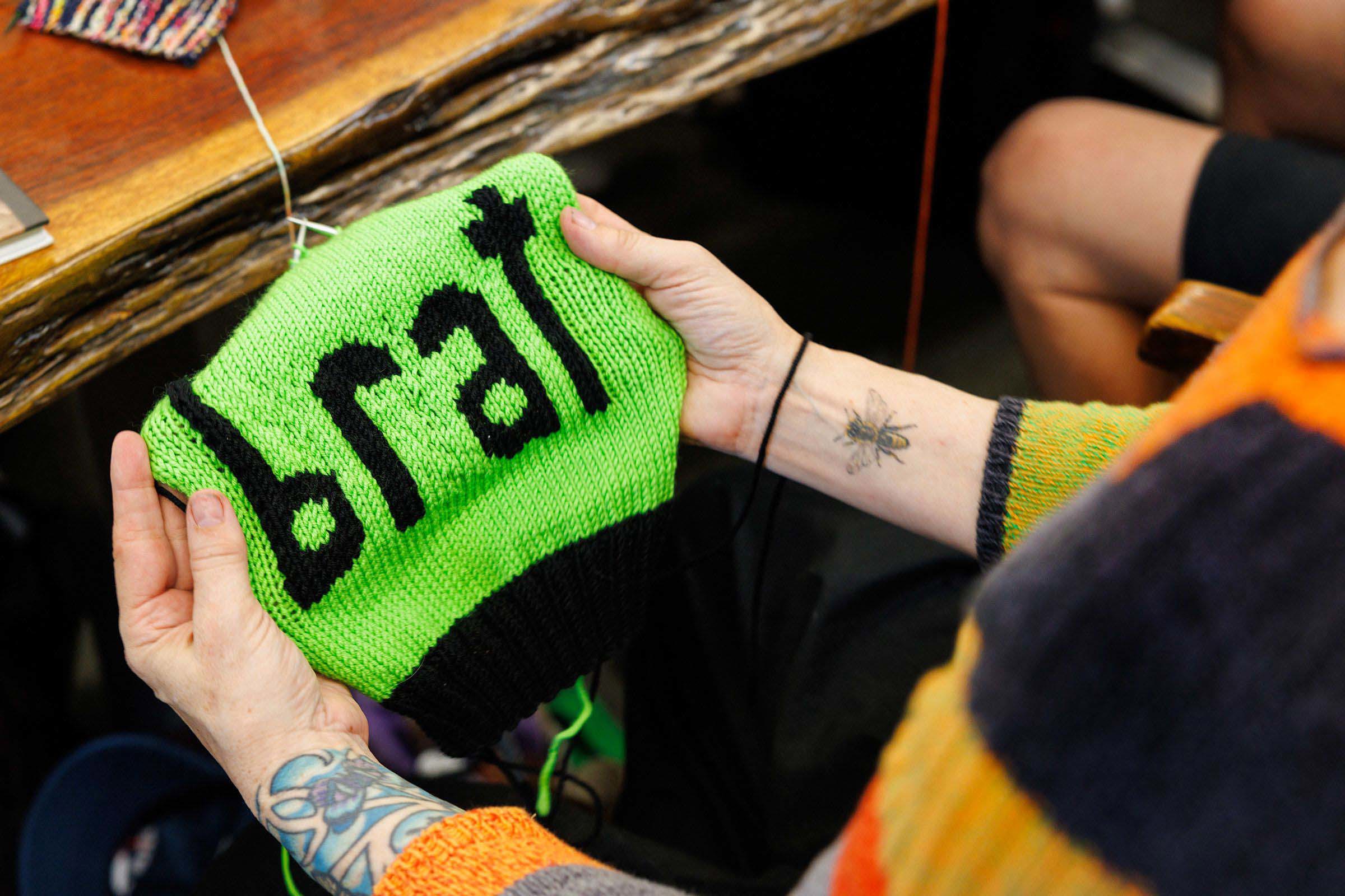 Annette Corsino, owner of the Knitting Tree LA, works on a "brat" hat in support of presidential candidate Vice President Kamala Harris in Inglewood, California, on July 31. Credit Gina Ferazzi/Los Angeles Times/Getty Images via CNN 