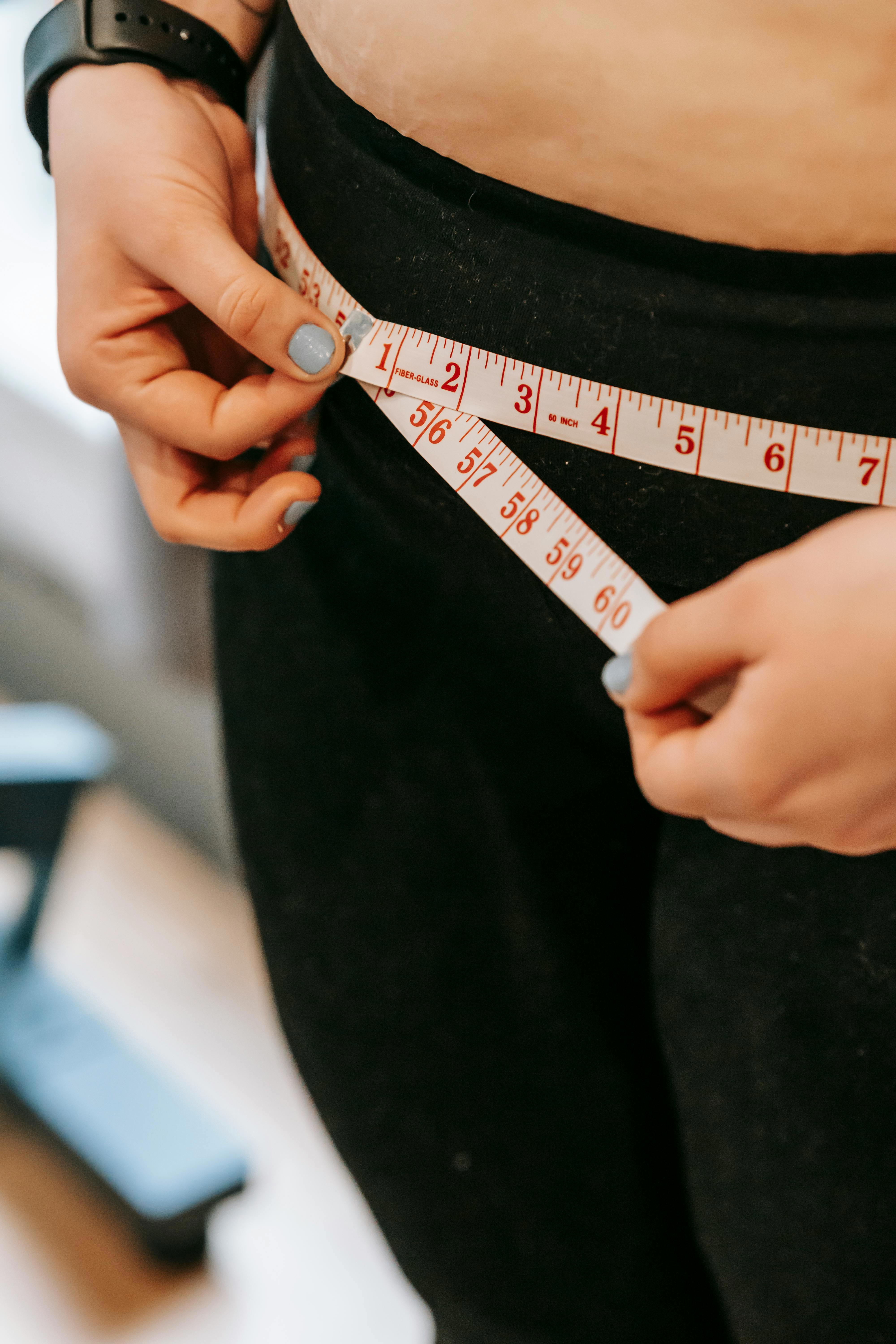 Stock image of a woman measuring her hips.