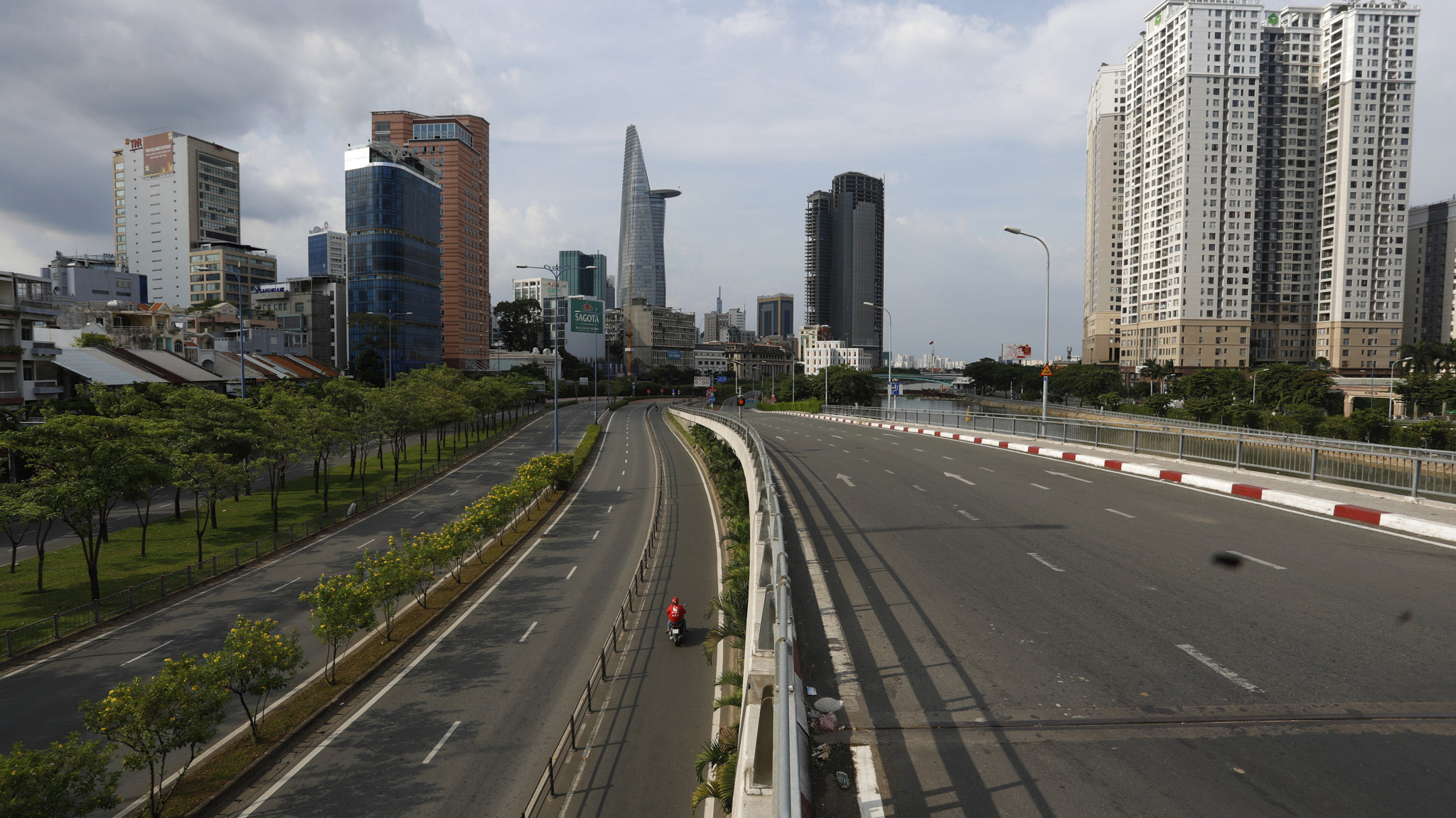 A man rides a scooter along a quiet street in Ho Chi Minh City, Vietnam.