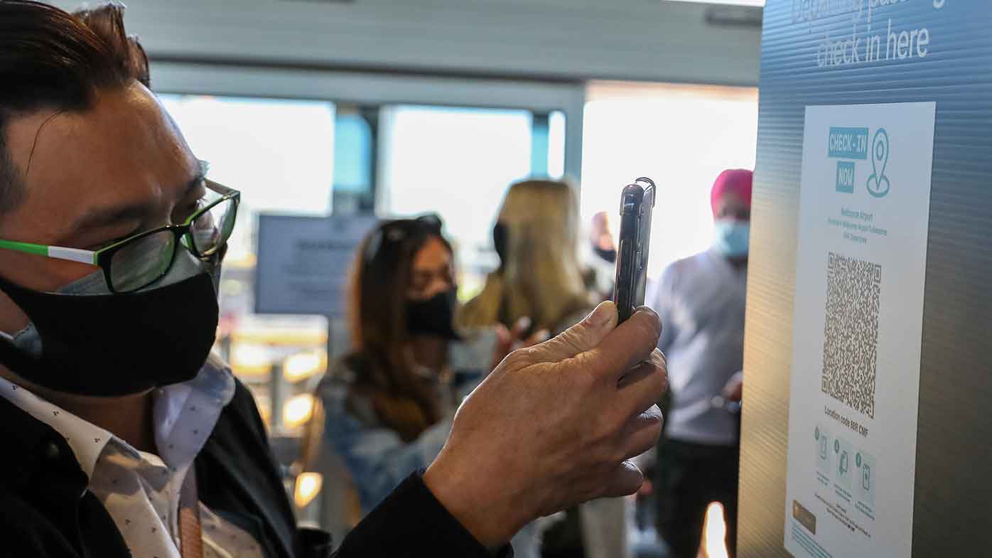 Domestic travellers from New South Wales are seen scanning QR codes upon arrival into the terminal.