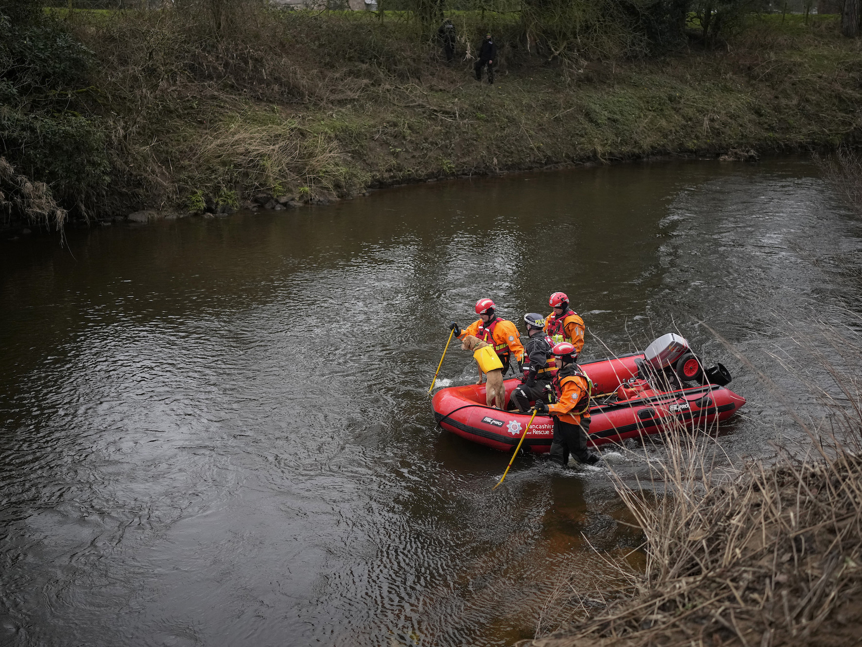 A search dog from Lancashire Police and a crew from Lancashire Fire and Rescue service search the River Wyre for missing woman Nicola Bulley in the village of St Michael's on Wyre, UK.