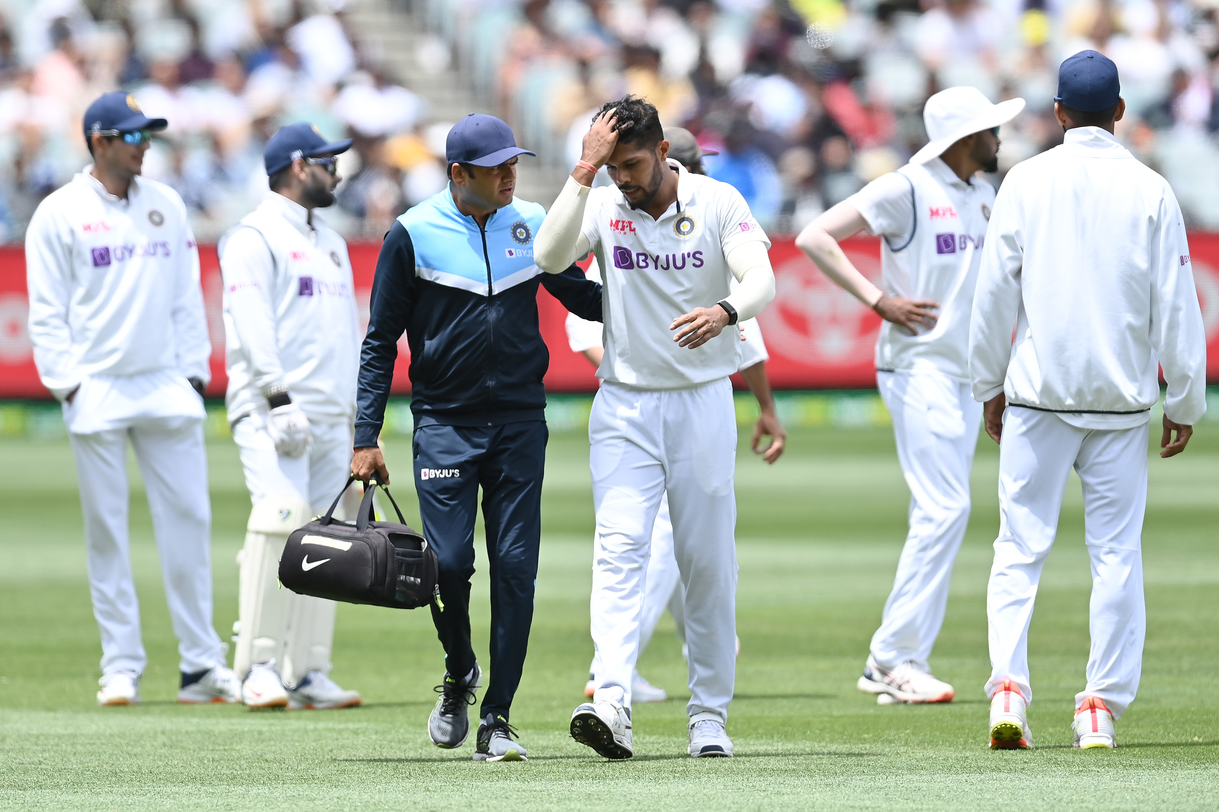 Umesh Yadav of India leaves the field injured at Melbourne Cricket Ground.