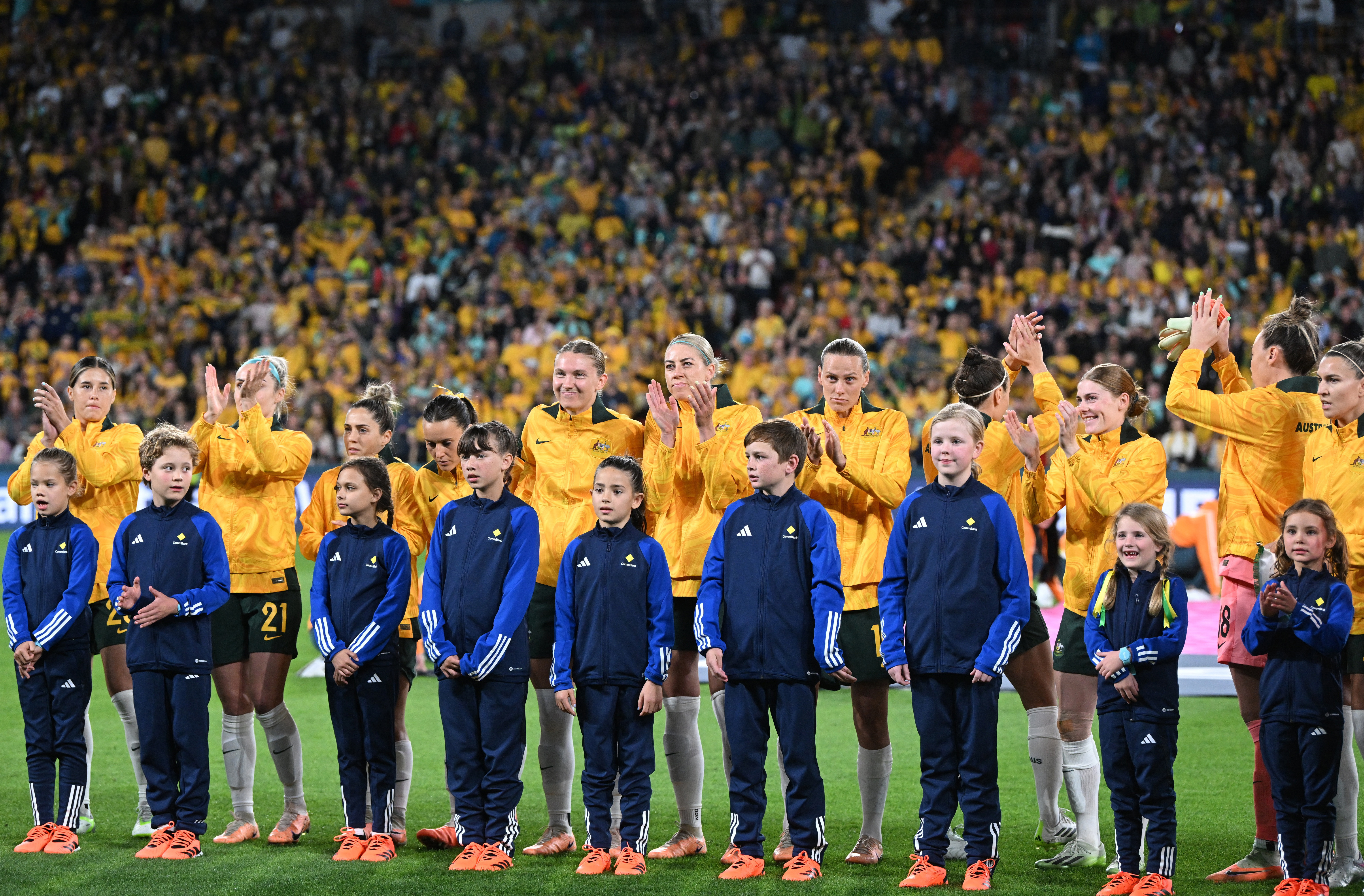 Australia acknowledge the crowd at the conclusion of the national anthem.