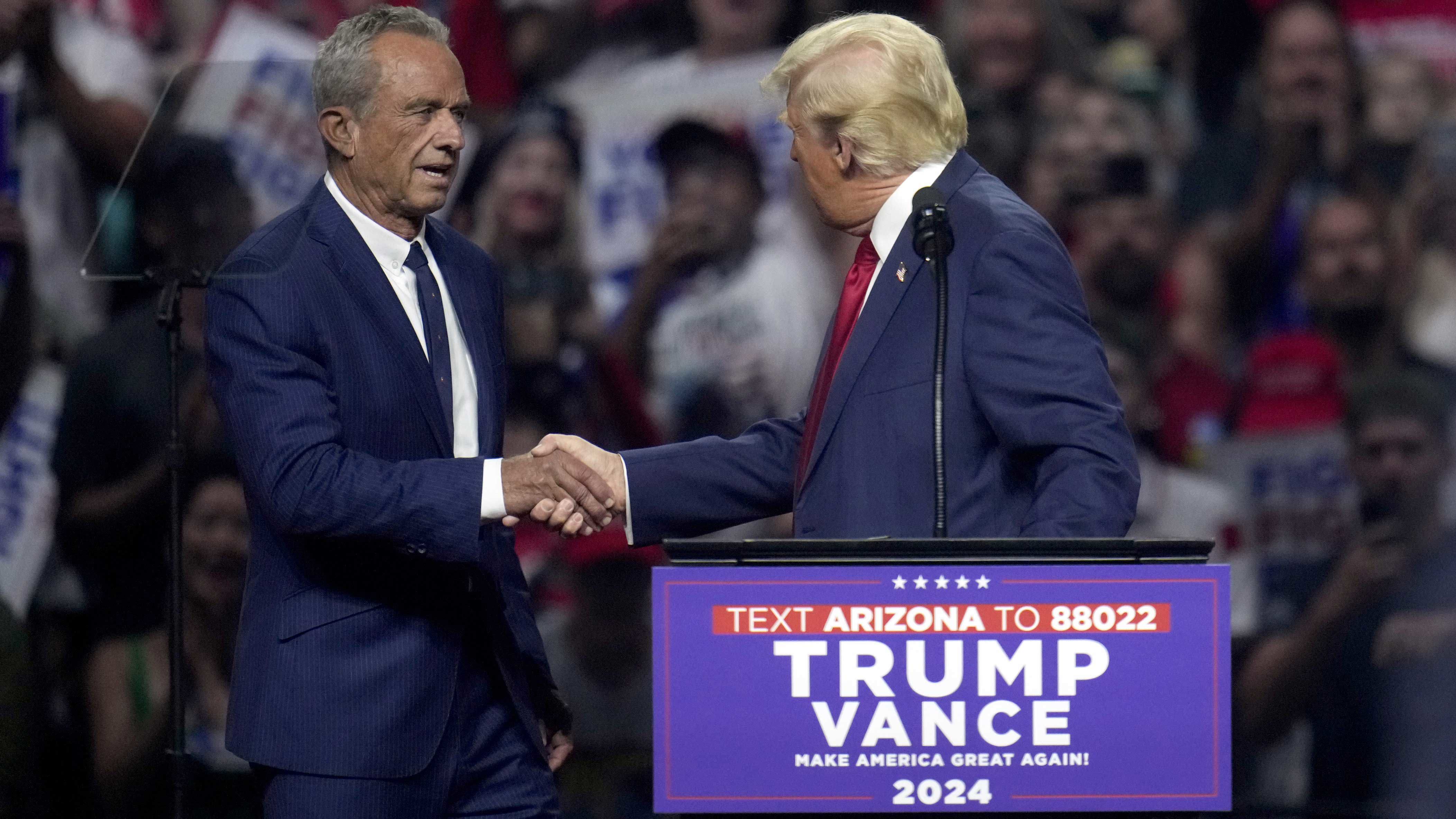 Robert F Kennedy Jr. da la mano con Donald Trump durante sus manifestaciones electorales.