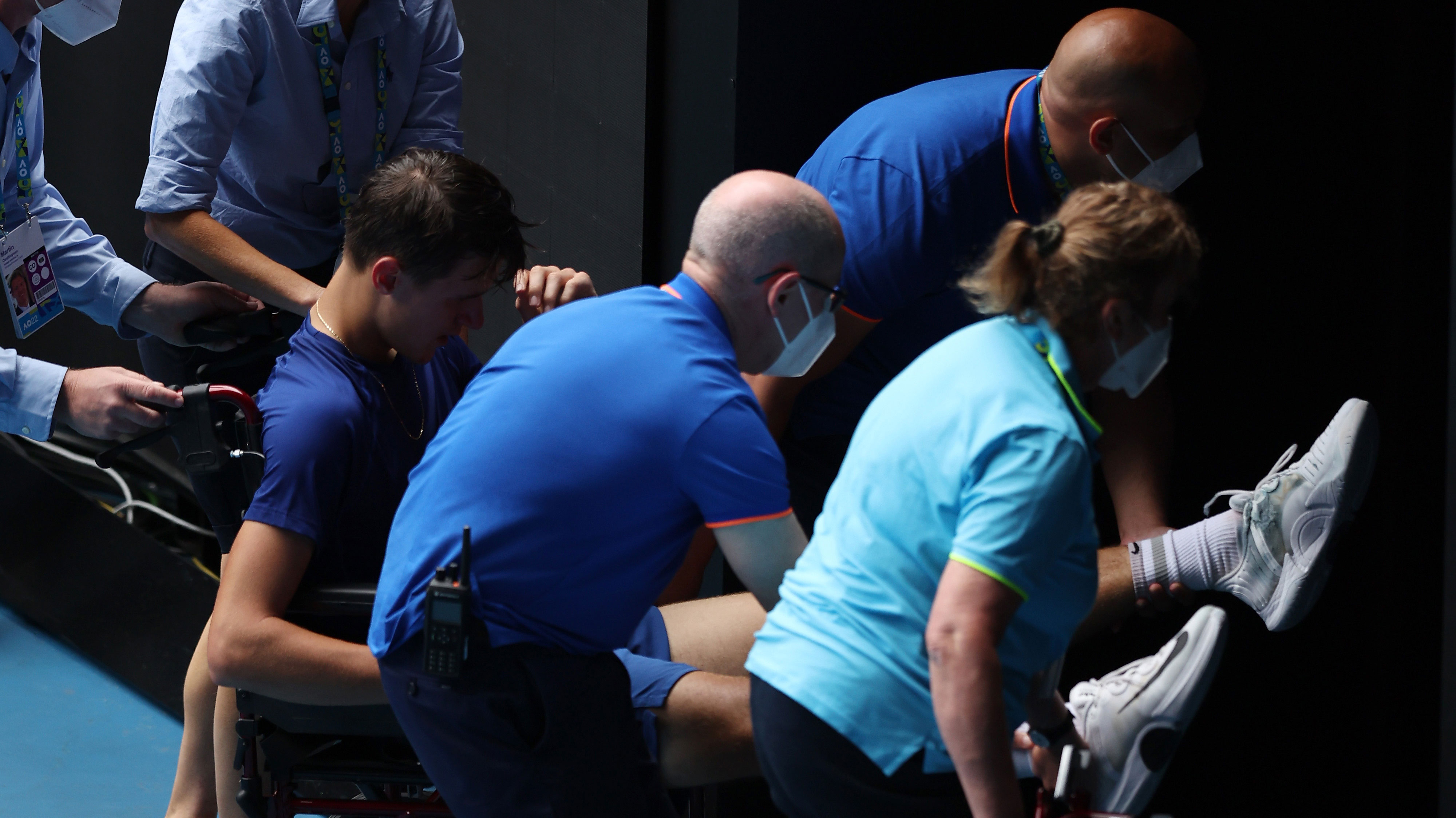 Jakub Mensik of Czech Republic is assisted from the court after collapsing at the end of the Australian Open junior boys final.