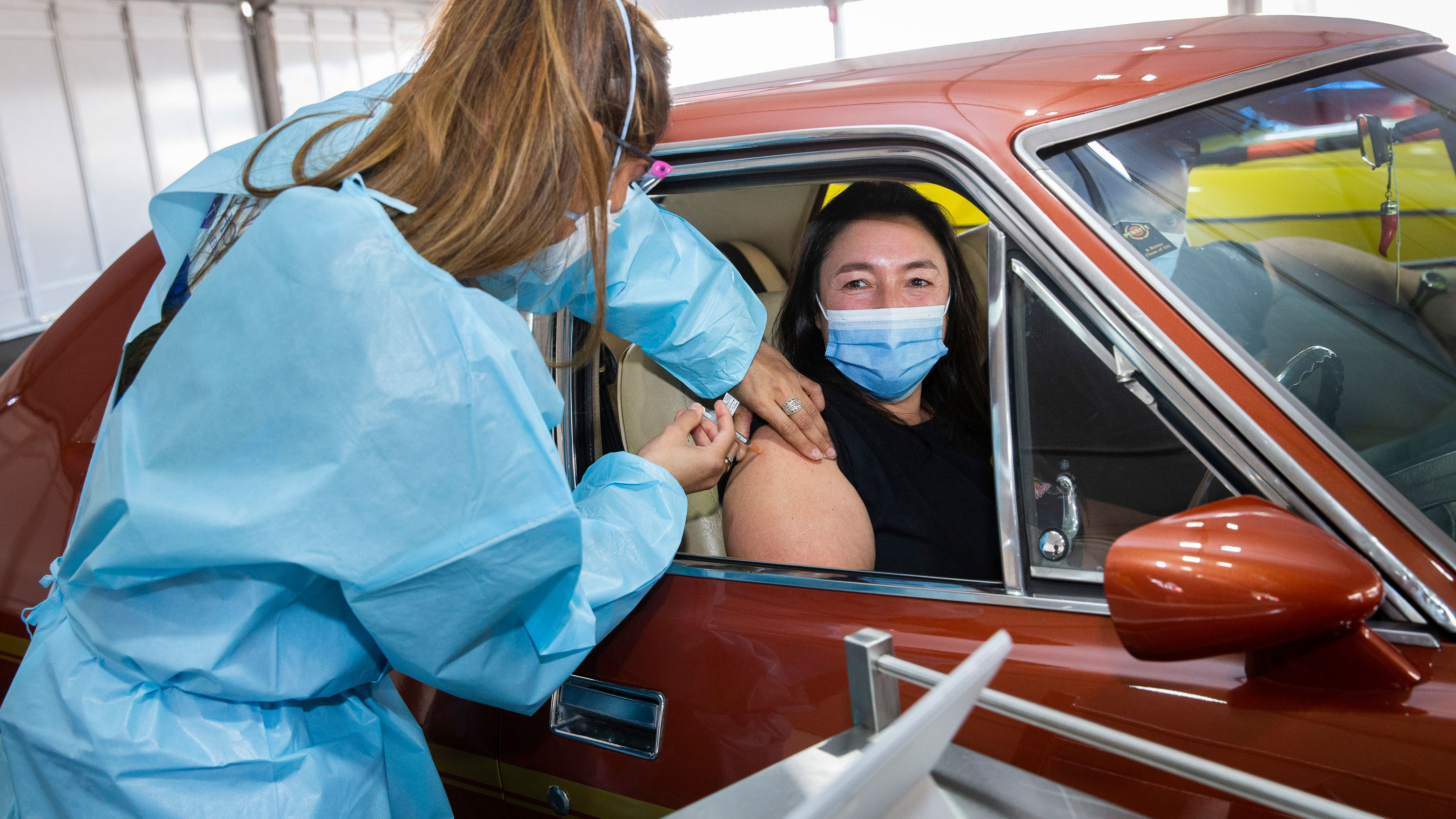 Paula Scarso recieves her first jab at the drive-thru vaccination centre in Campbellfield, Melbourne.