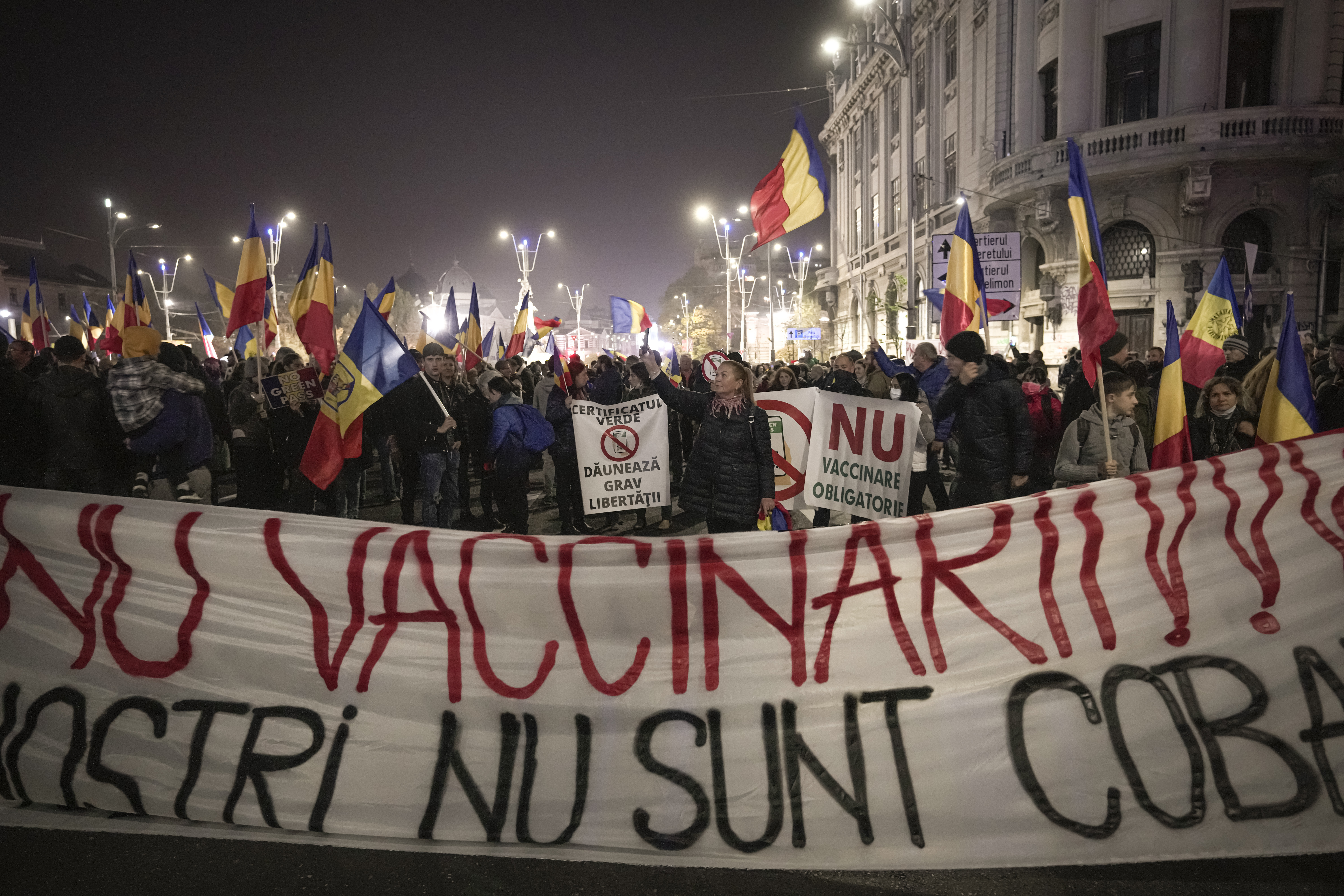 People hold a large banner that reads "No to Vaccination - Our Children are not your guinea pigs" during a protest against vaccinations in Bucharest, Romania. 