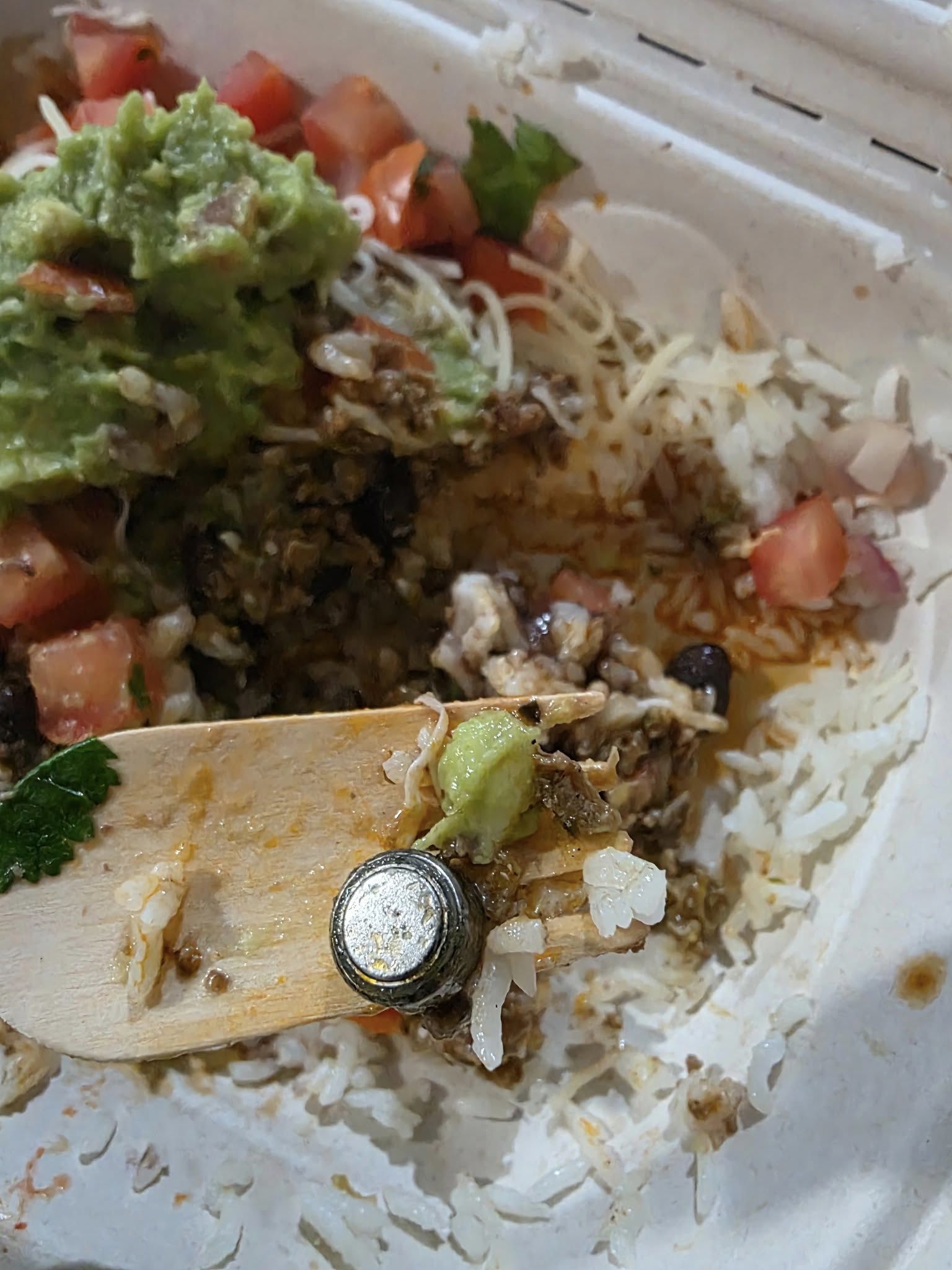 What appears to be a button battery in a Guzman y Gomez burrito bowl.