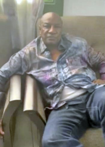 In this image made from a video released on Sunday, Guinean President Alpha Conde sits on a sofa in an unknown location.