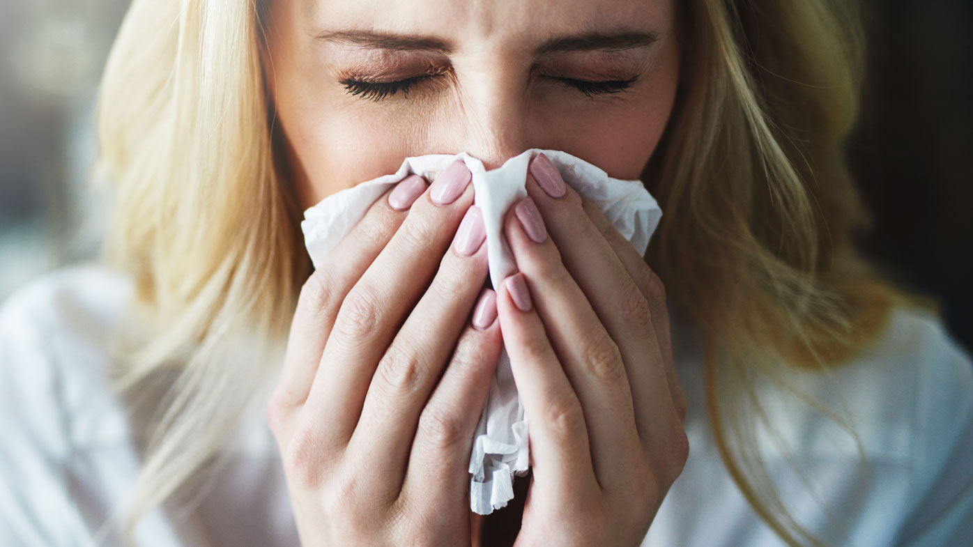 Woman blowing nose