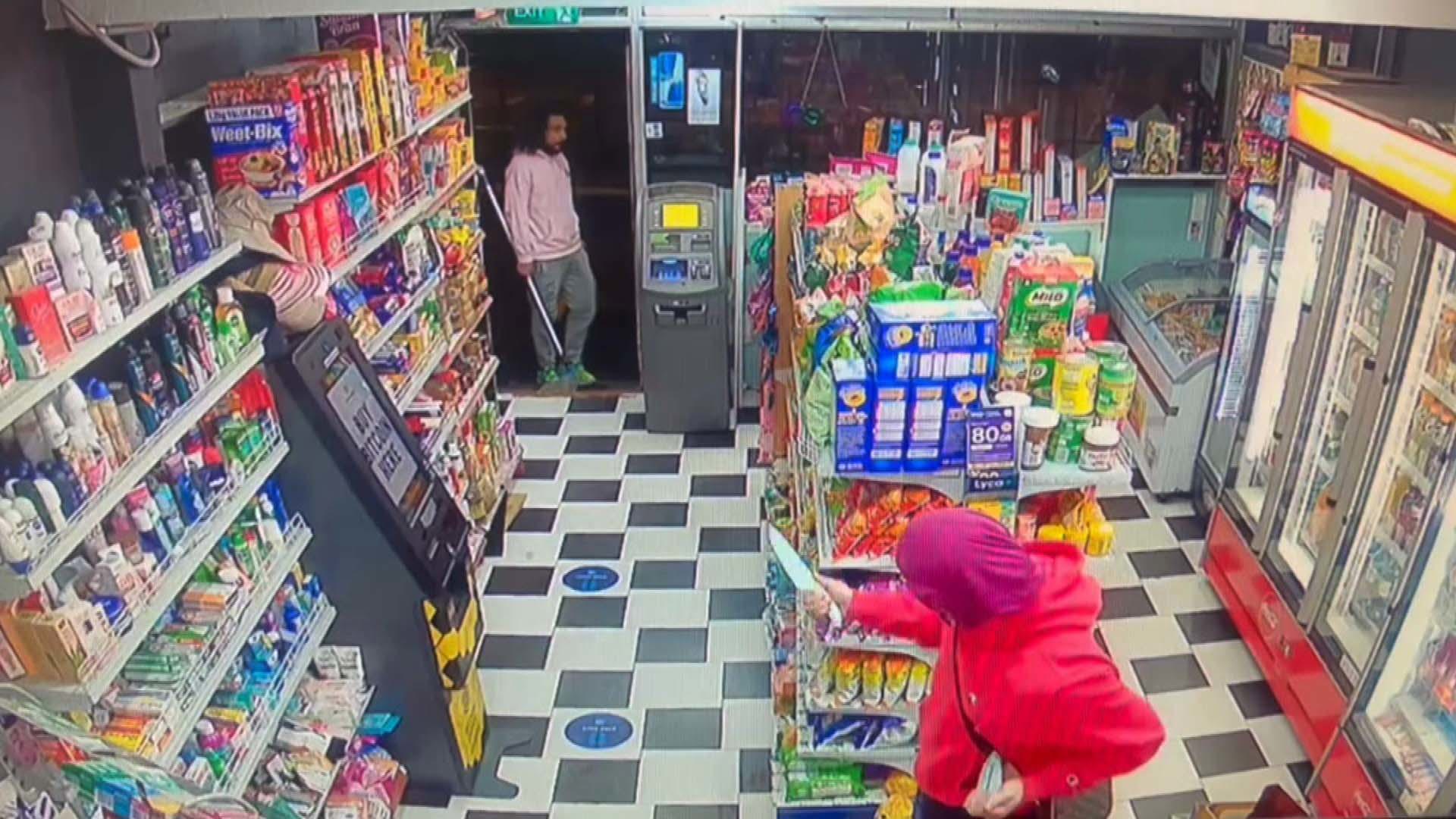 CCTV from Aruma Grocery on the next street shows a man in a mask wielding a large knife.