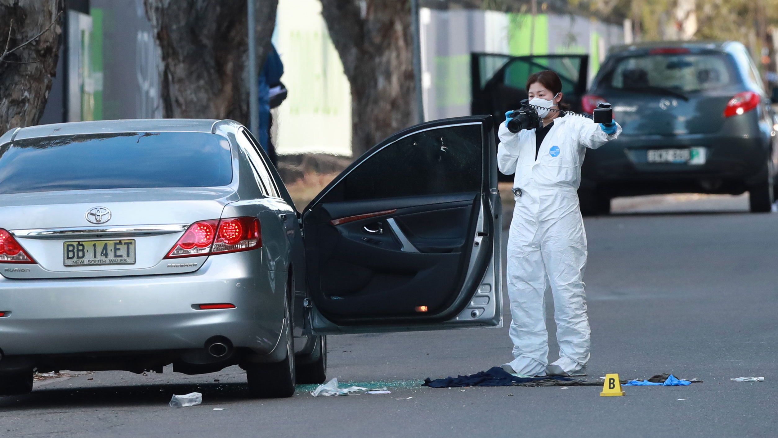 The scene of the shooting at Greenacre. Two men and a woman were shot while sitting in their cars. Bullet holes are seen in the car window.