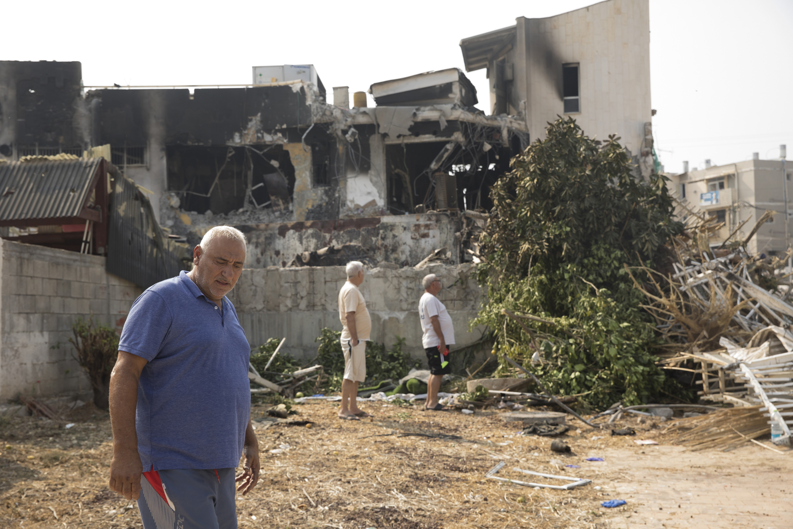 People pass a police station that was destroyed after a battle between Israeli troops and Hamas militants on October in Sderot, Israel.