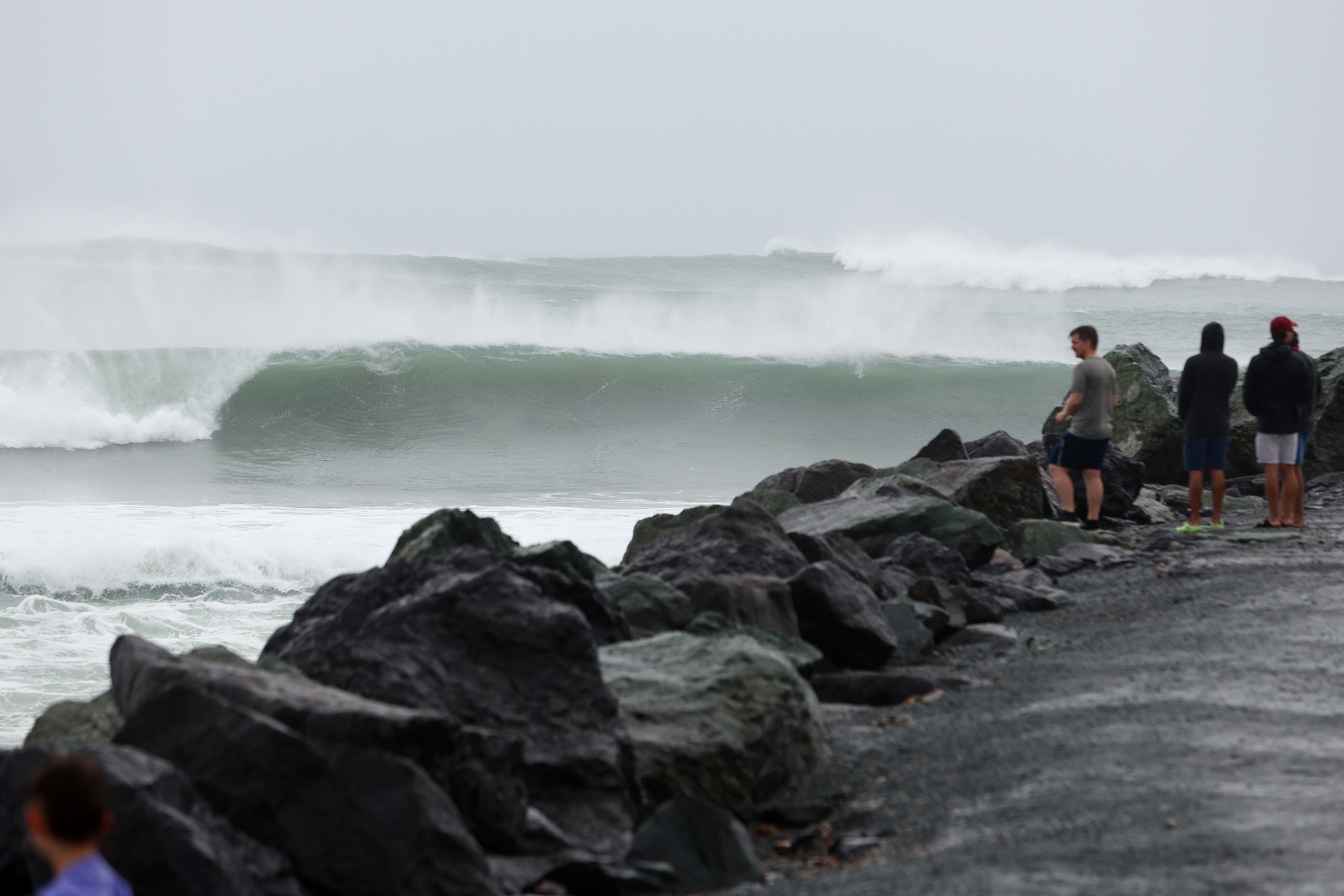 GOLD COAST, AUSTRALIA - MARCH 05: People watch the waves at Kirra Beach on March 05, 2025 in Gold Coast, Australia. Tropical Cyclone Alfred is expected to make landfall in southeast Queensland as a Category 2 storm, marking the first time a cyclone has directly hit the region in over 50 years. The storm is forecast to bring damaging winds, heavy rainfall, and potential storm surges, prompting authorities to urge residents to prepare for significant impacts, including flooding and power outages. 