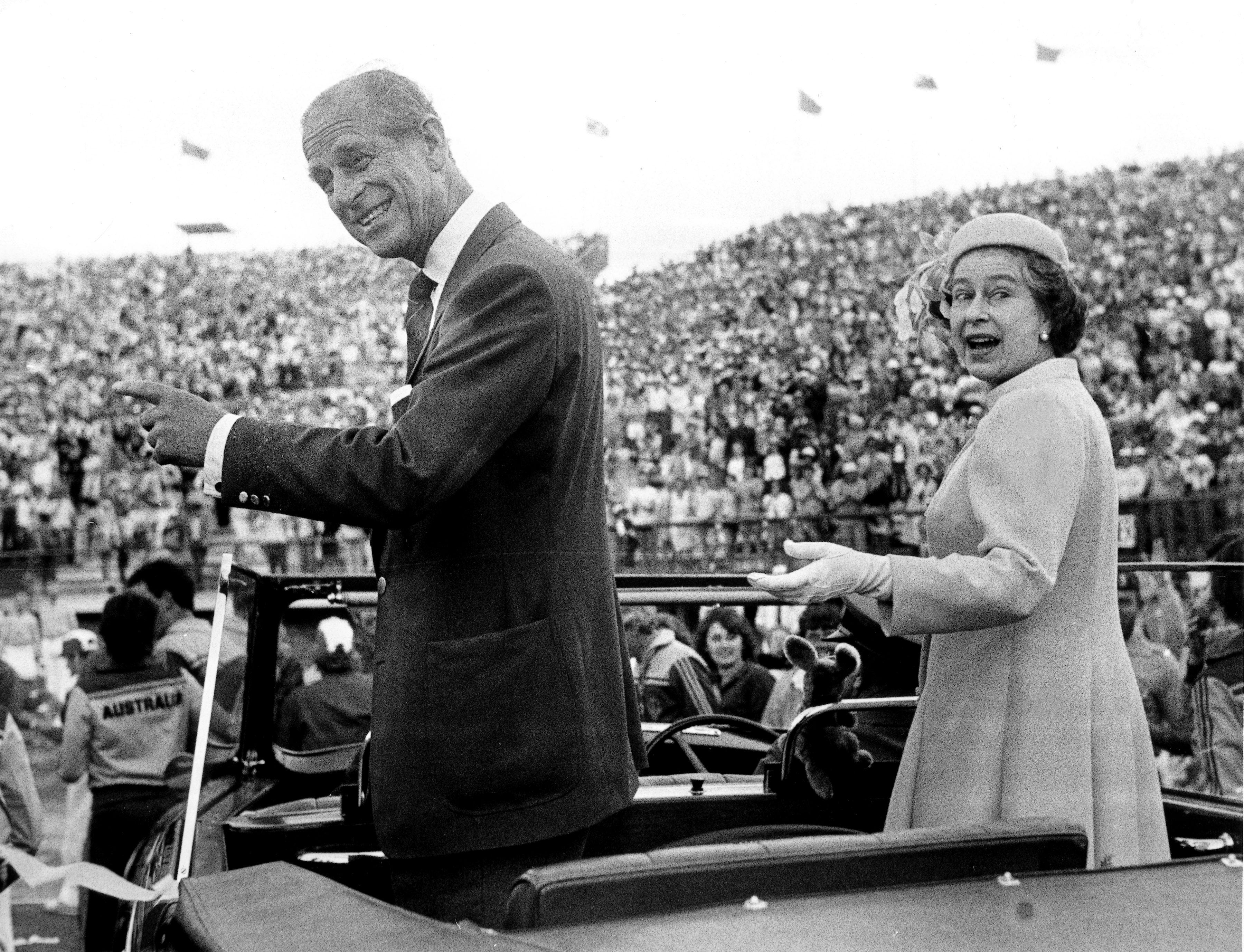 Queen Elizabeth and Prince Philip look back as they drive through the crowd of athletes and officials during the closing ceremony of the 12th Commonwealth Games, in the Queen Elizabeth II Jubilee Sports Centre, Brisbane, in 1982.