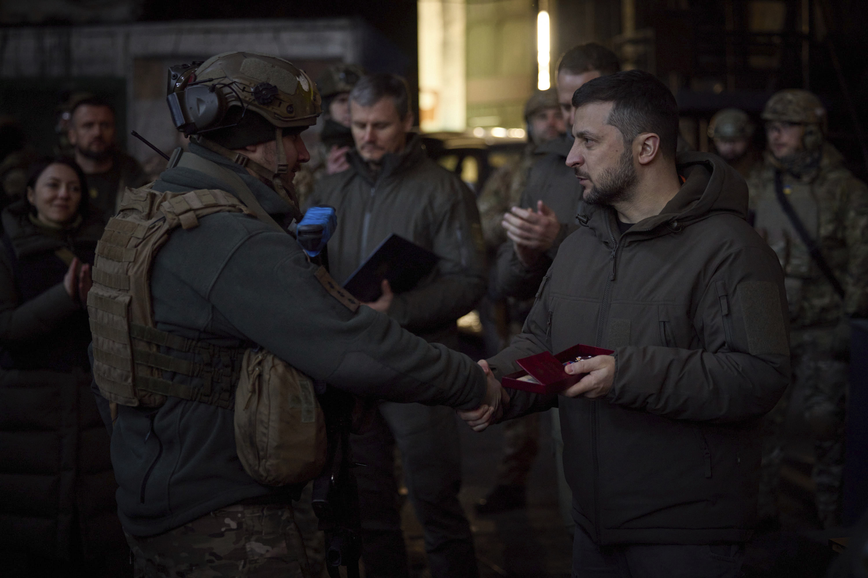 Ukrainian President Volodymyr Zelenskyy, right, awards a serviceman at the site of the heaviest battles with the Russian invaders in Bakhmut, Ukraine, Tuesday, Dec. 20, 2022. 